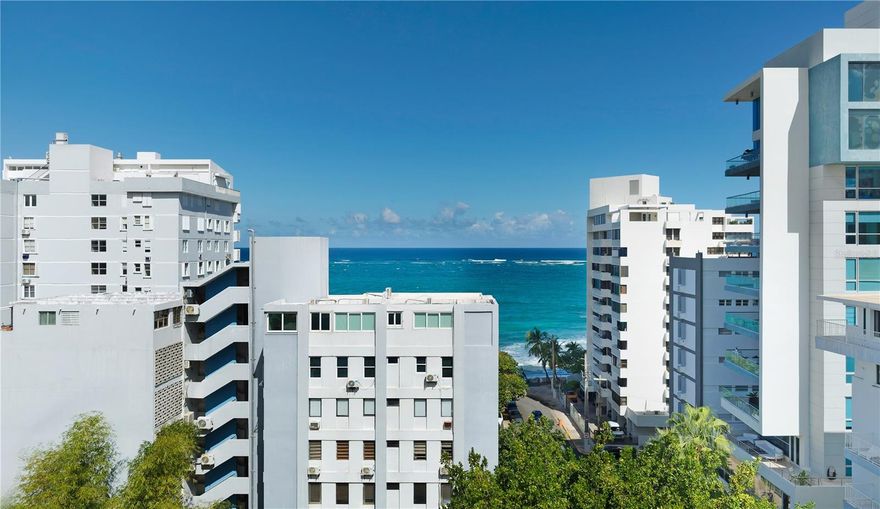 Set just moments away from the Atlantic in one of Condado Beach’s most desirable residential streets, this elegant two-story residence at Del Rey condominium offers a rare blend of space, light, and coastal urban living. Spanning approximately 2,079 square feet, the main living level welcomes you with an open living, dining, and kitchen concept, enhanced by ocean views from the living room and warm wood finishes throughout. An open bedroom area, full bath, guest half bath, and separate laundry room complete this level, while the flexible layout allows the current two-bedroom configuration to be converted into three bedrooms. Below, the private lower level is dedicated to rest and retreat, featuring a generously-sized primary suite with custom built-in storage, well-appointed en-suite bathroom and sauna. The gated building offers covered parking and a full power generator, ensuring comfort and peace of mind year-round. Within close proximity to the beach and the vibrant heart of Condado Beach, this residence delivers a refined lifestyle defined by space, privacy, and effortless coastal access. Condado Beach is one of San Juan’s most iconic coastal neighborhoods, known for its vibrant energy and refined oceanfront lifestyle. Residents enjoy immediate access to a wide selection of acclaimed restaurants, cafes, boutique shopping, fitness studios, and everyday services. Its central location provides quick connectivity to Old San Juan, Miramar, Isla Verde, and the international airport, making Condado Beach a premier choice for full-time living or an elegant second-home retreat.
