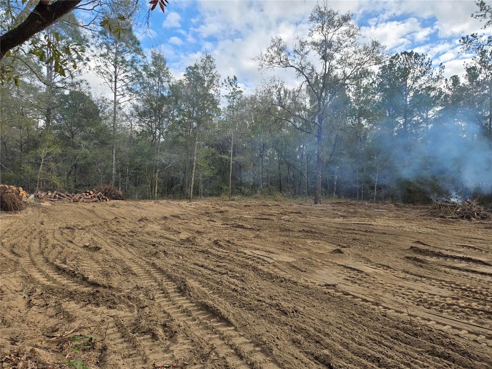 Discover the perfect blend of country living and modern convenience with this 1-acre parcel (210x210 ft) in Williston, FL. Zoned Residential Agricultural, this property offers endless opportunities—whether you’re looking to build your dream home, establish a small homestead, or invest for the future.
A 105x105 ft cleared, de-stumped, and graded area is ready for immediate construction. The property also features a gravel driveway with charming ranch-style arches, plus an electric pole already in place, saving you time and expense in the building process. Accessible year-round, this is the only lot in the area that’s cleared, graded, and equipped with a driveway—a rare find! Also, there are no minimum square footage requirements to build. Ideal for tiny homes, manufactured homes, or even a site built single family home. The only thing the county asks is that you follow Florida Building Code.
Enjoy privacy and space while staying close to conveniences: schools, shopping, and dining are just minutes away. Major hubs like Ocala and Gainesville are a short drive, with easy access to nearby highways and the interstate.
As a bonus, the seller is offering a $1,000 credit toward clearing seasonal weeds upon purchase—making this land even more turn-key.
Lot 8, an adjacent 1-acre lot, is also available.
