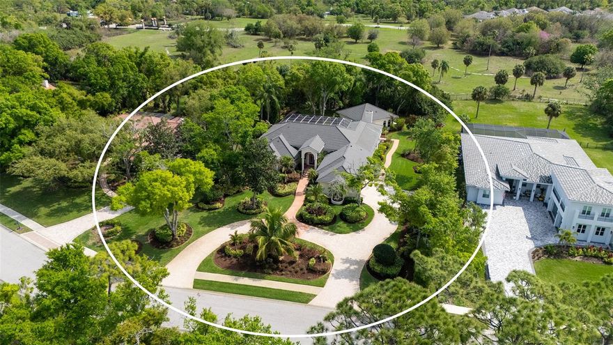 Nestled amongst stately trees you will discover the coveted community of Ashley.   Privacy galore and estate sized homes where each are individually designed to offer sophistication without being overstated.  This expansive 4 Bedroom, 2.5 Bath (with addition totaling 6 Bedrooms, 4.5 Baths), offers 5154 sq ft and sits on nearly an acre, creating a true private mini estate. Set back from the road, the home features a long paver driveway and lush landscape that enhance its grand curb appeal. Inviting leaded doors open to an enormous living room with volume ceilings, quadruple sliders overlooking the patio and pool area, seamlessly blending indoor and outdoor living.  The formal dining room is elevated by a stunning Murano glass chandelier, and throughout the home you will appreciate the sellers’ collaboration with interior designer Anne Folsom Smith, reflected in the thoughtful details and refined finishes. The heart of the home is the well-appointed kitchen, featuring a center island with sink and instant hot water, extensive stone countertops, island cooktop, stainless appliances including double oven, warming drawer and Sub-Zero refrigerator, along with designer cabinetry. An adjoining built-in breakfast nook easily accommodates gatherings of any size. Just steps away, the family room offers a warm and inviting space with propane gas fireplace and custom designer built-ins – perfect for everyday living and entertaining.  The primary suite is a true retreat and a statement in design, featuring an oversized jetted tub, custom multi-head shower, instant hot water system, dual vanities, and 2 walk-in closets.  All secondary bedrooms are generous in size, including the fourth bedroom, which is currently utilized as a den/office with custom built-ins, offering flexibility to suit your needs. Enhancing the home’s versatility is a newer addition featuring a 2-bedroom, 2 bath suite complete with kitchenette and its own washer/dryer. This unique space offers two separate entrances – double doors off the family room that allow it to function as a seamless extension of the living area, as well as a private exterior entrance for added independence and privacy – ideal for multigenerational living, guests, or flexible lifestyle needs. Impact windows on the addition add to this special area.  The enclosed pool area provides a serene outdoor escape with a shaded seating area and oversized lanai, perfect for year-round enjoyment.  Additional features include a whole house water filter and softener system, central vacuum, 4 HVAC systems (including garage), irrigation system with new tank, electric pool heater, propane generator, 3 garbage disposals, 2 dishwashers, and a new roof installed in 2020.  Conveniently located near shopping, dining options, I-75, A-rated schools, golf, and Gulf beaches, this exceptional property is a rare opportunity offering space, privacy, and flexibility in a highly desirable setting.