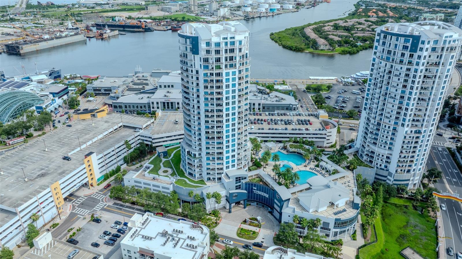 Welcome to a true work of art in the sky — a fully custom-designed, two-story penthouse located in the heart of Downtown Tampa. Originally purchased as a cement shell, this exceptional residence has been transformed into a highly developed showpiece with every detail curated for luxury and comfort. Step off your private elevator into a space filled with natural light, blonde hardwood floors, and soaring floor-to-ceiling windows that frame panoramic views of the city and beyond. The open-concept layout flows seamlessly between indoor and outdoor dining areas, ideal for entertaining or simply enjoying the Florida breeze. Every element of this home was thoughtfully crafted, from the rounded feature room that adds architectural flair to the custom wine storage and bright, cheerful living spaces. The sleek, modern kitchen and living area open onto generous balconies with captivating views—perfect for sunset cocktails or morning coffee. Located in the iconic Towers of Channelside, residents enjoy easy access to major highways, train and air travel, and are just a short drive from the Gulf beaches and Disney. Live steps from Tampa's Riverwalk, Amalie Arena, Sparkman Wharf, and Water Street. This is not just a home—it’s a statement.