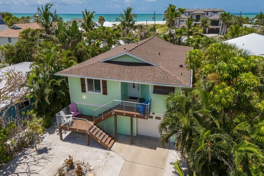 Welcome to Limelight — a beautifully appointed and fully furnished 3-bedroom, 2-bath coastal retreat ideally located on the coveted north end of Anna Maria Island, just steps from direct beach access. Light-filled interiors and swaying palms greet you upon entry, setting the tone for relaxed island living. Vaulted white wood-plank ceilings, custom millwork, wainscoting, and rich wood flooring create a warm and refined ambiance throughout the open living and dining spaces.

The kitchen, perfectly integrated with the main living area, features stainless steel appliances, granite countertops, a custom tile backsplash, breakfast bar, and a reverse osmosis drinking water system. The spacious primary suite includes a walk-in closet and en-suite bath with a walk-in shower. All bedrooms are finished with crown molding, custom wood trim, and wood floors, adding a touch of timeless character.

Step outside to the covered patio — the perfect spot to sip your morning coffee or toast the sunset. On the ground level, a stunning open-air living area offers relaxed lounging, alfresco dining, and even space to design your dream poolside bar — all enhanced by electric roll-down screens and hurricane shutters. The heated freeform pool is surrounded by lush tropical landscaping, offering complete privacy, along with a hot/cold outdoor shower.

Additional highlights include: a 2-car tandem garage with impact door, interior laundry with storage, impact-rated doors and windows, app-controlled tankless hot water heater and HVAC with AirKnight air purification, water softener and chlorine removal system, 2020 exterior stair and railing upgrades, 2024 new Tv in cabana area, 2024 new roof and an efficient drainage system.

Whether you’re looking for a full-time residence, second home, or investment opportunity, this island gem is move-in ready with  nightly rentals permitted. Experience the best of Anna Maria living — laid-back luxury just moments from the Gulf.