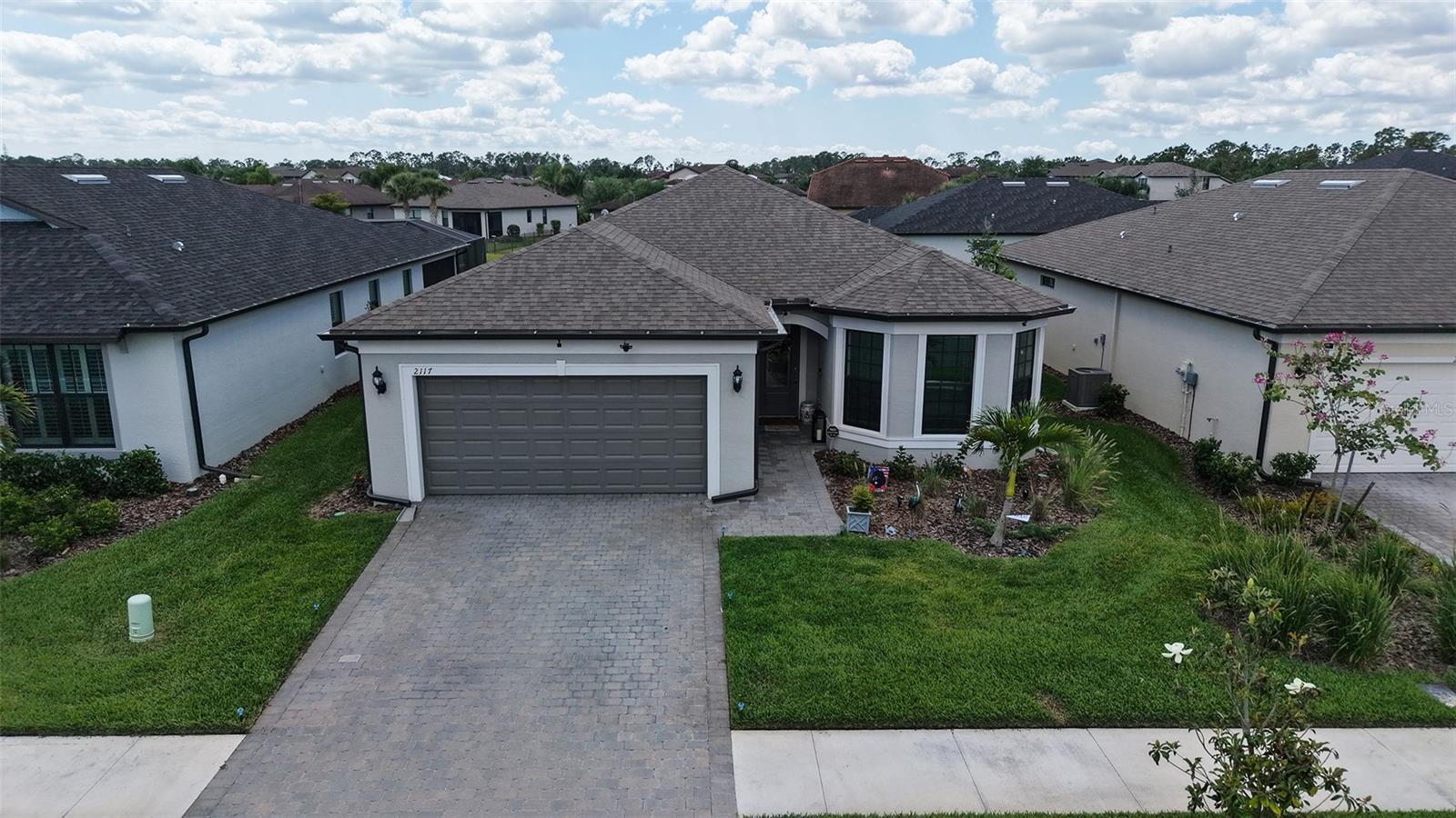 WELCOME HOME! TAKE ANOTHER LOOK!! NICE PRICE IMPROVEMENT! TAKE ADVANTAGE OF THE SELLERS OFFERING A INCENTIVE FOR BUYERS CLOSING COST IN THE AMOUNT OF $3,000.00. This stunning 3-bedroom, den and 2-bathroom haven nestled in sought after Cedar Grove at the Woodlands. This well-maintained community has a community pool and playground minutes away. Situated just a short drive from the Gulf beaches, this residence boasts impeccable curb appeal with upgraded landscaping that sets the tone for what lies beyond. Step through the front door and be greeted by a hurricane rated intricate etched glass, a prelude to the elegance that awaits within. The spacious entry hall beckons you further into the home, where you'll find 8' doors, and window treatments adorning every window, exuding a sense of refined luxury. All windows are Hurricane rated. High-quality ceiling fans in the living room and guest room and Primary Bedroom, ensuring comfort throughout. The heart of the home is its expansive open-concept living space, ideal for hosting gatherings with loved ones. The generously sized guest rooms and den, complete with a shared bathroom featuring quartz countertops and a tall vanity, provide comfortable accommodations for guests. The kitchen is a chef's dream, boasting an upgraded appliance package, quartz countertops, a tile backsplash, and 42" upper cabinets surrounding a large island. Meanwhile, the primary bedroom, tucked away at the rear of the home, offers tranquility and serenity with its picturesque view of the pond. The primary bathroom is a sanctuary unto itself, featuring a spacious walk-in shower with upgraded tile from floor to ceiling, a tall vanity with dual bowls, and quartz countertops. A large walk-in closet with ample shelving provides plenty of storage space for your wardrobe. Conveniently located near the garage, the laundry room boasts cabinetry and a laundry sink for added convenience. Step outside from the Living room area onto the large covered lanai, a perfect setting for outdoor entertainment and relaxation. The garage, with its 4' extension, offers ample space for vehicles, golf cart parking and recently added ceiling racks for extra storage. Sellers have included a one year warranty from American Home Shield as well as the remainder of the builders warranty to give you added comfort.