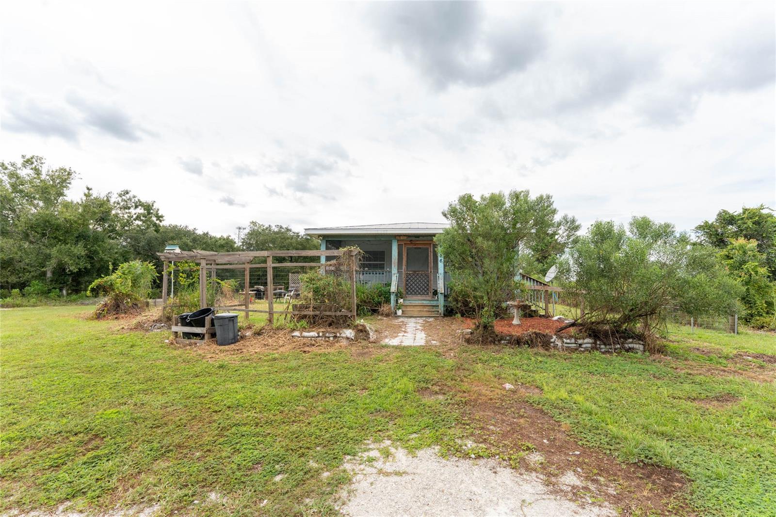 Escape to your own slice of rural Florida with this expansive 2.10 acre property with plenty of trees and lush landscape. Extra lot included that is you can build another home on. This property features a 1BR/BR cottage with front screened porch to enjoy the quiet country living. There is plenty of room inside to add a second bathroom and 2nd bedroom. A detached 1/1 BA mother in law suite with a separate entrance would be greatly offered to seasonal travelers or extra company. There is also a 30 amp RV hookup, large fenced dog run, bring your goats and horses because there is room for them too, a fortress of a chicken coop with hen house, and plenty of outbuilding storage to keep all of your outdoors toys under cover. Located on a dead end road, you will have plenty of privacy. Make sure you schedule a showing to see this before its gone. This property offers so many opportunities from building your dream home, featuring this property as a seasonal rental, or just making it your own farm.