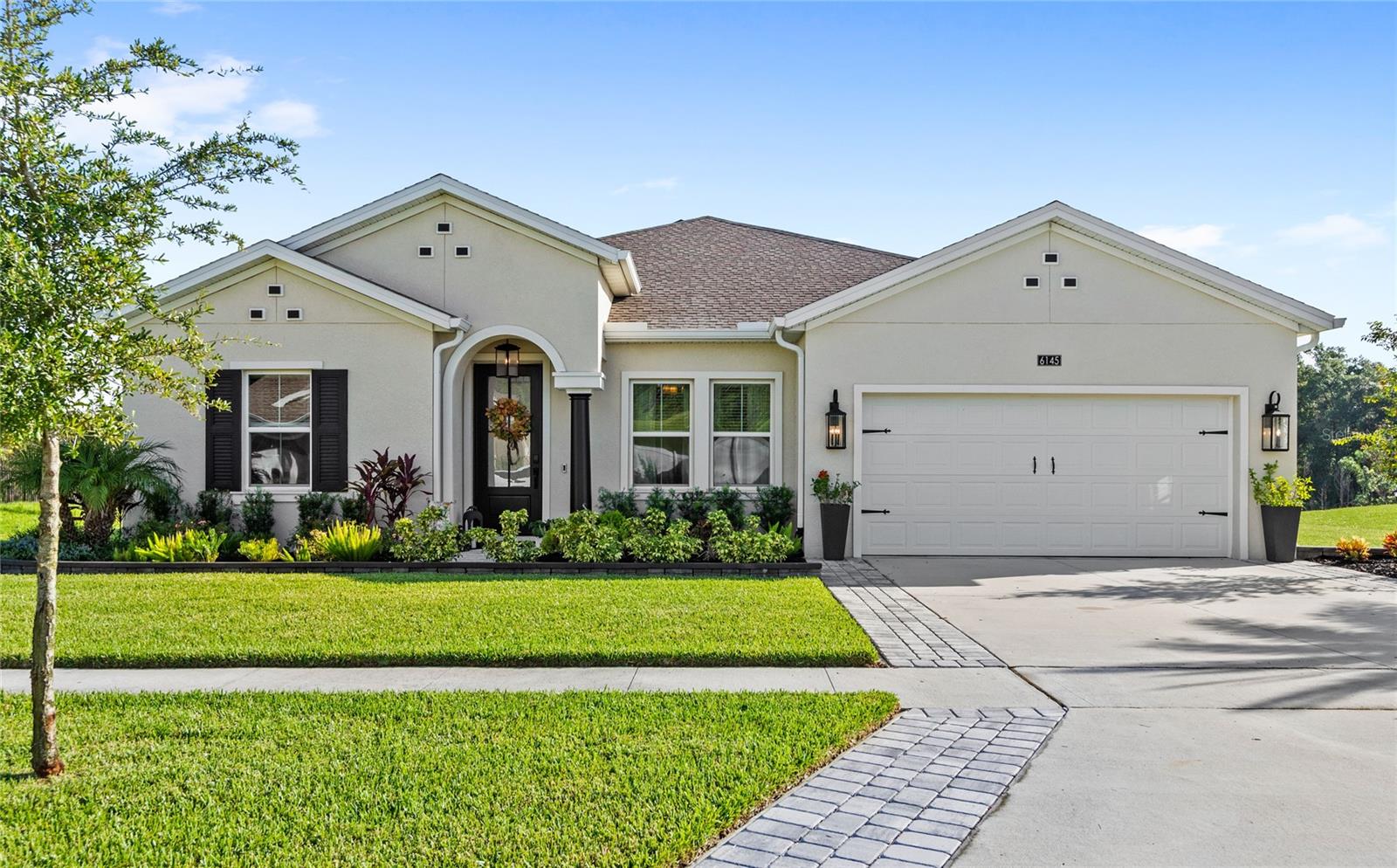 Welcome to 6145 Claystone Way, a fully upgraded Inverness model situated in the exclusive, gated community of Hillside Estates in Mount Dora. This home offers over 3,000 square feet, is single story, and features 4 bedrooms, 3.5 bathrooms, space for a dedicated office, a game room, and a 2-car garage. The floor plan is laid out with a functional three-way split floor plan, and with all of its new upgrades, it is nothing like the builder offered it. From the moment you arrive, the curb appeal is evident. A custom front door with decorative glass panels adds character and enhances the natural light throughout the entryway. Inside, the home features expansive windows and 9’4” ceilings that contribute to the open feel.
The gourmet kitchen features custom Calacatta quartz countertops that elevate the entire space. The kitchen also features upgraded Samsung Bespoke appliances, including: a smart refrigerator, oven, microwave, and dishwasher, all with the optional Wi-Fi connectivity. The space is accented with matte black and gold hardware, offering a cohesive, designer finish on faucets, showerheads, and door hardware throughout. The kitchen overlooks the great room, and has views directly out of the large sliding glass door to the lanai and the tree lined view in the back. Adjacent to the kitchen is the breakfast nook, and the game room, also functional as a formal dining room. The home is completed with high-end lighting upgrades, including pendant lights, chandeliers, and ceiling fans, in every room. The home's thoughtful layout includes a large primary suite tucked away for privacy and 3 additional bedrooms situated in separate wings.
Step outside to enjoy the expansive under-roof lanai, fully screened and complete with ceiling fans. This outdoor space overlooks a view of trees and water. The exterior includes upgraded landscaping, including an oversized Sylvester palm, new plantings, garden edging, and a driveway extension with a paver sidewalk. Additional outdoor upgrades include: new sconce and pendant lighting, as well as gutters with trench drains.
Additional features of the home, include the Ecobee Wi-Fi controlled HVAC system. Located within Hillside Estates, residents enjoy top-tier amenities including a resort-style pool, clubhouse, fitness center, lit tennis and pickleball courts, sports courts, walking trails, and more. A Publix supermarket sits just outside the gates, and the community is ideally positioned with quick access to downtown Mount Dora’s shops and restaurants. With SR 429 nearby, you're just 30 minutes from Winter Garden and downtown Orlando, and also conveniently located within an easy drive to Disney, and the Orlando International Airport. Call today to schedule a private tour.