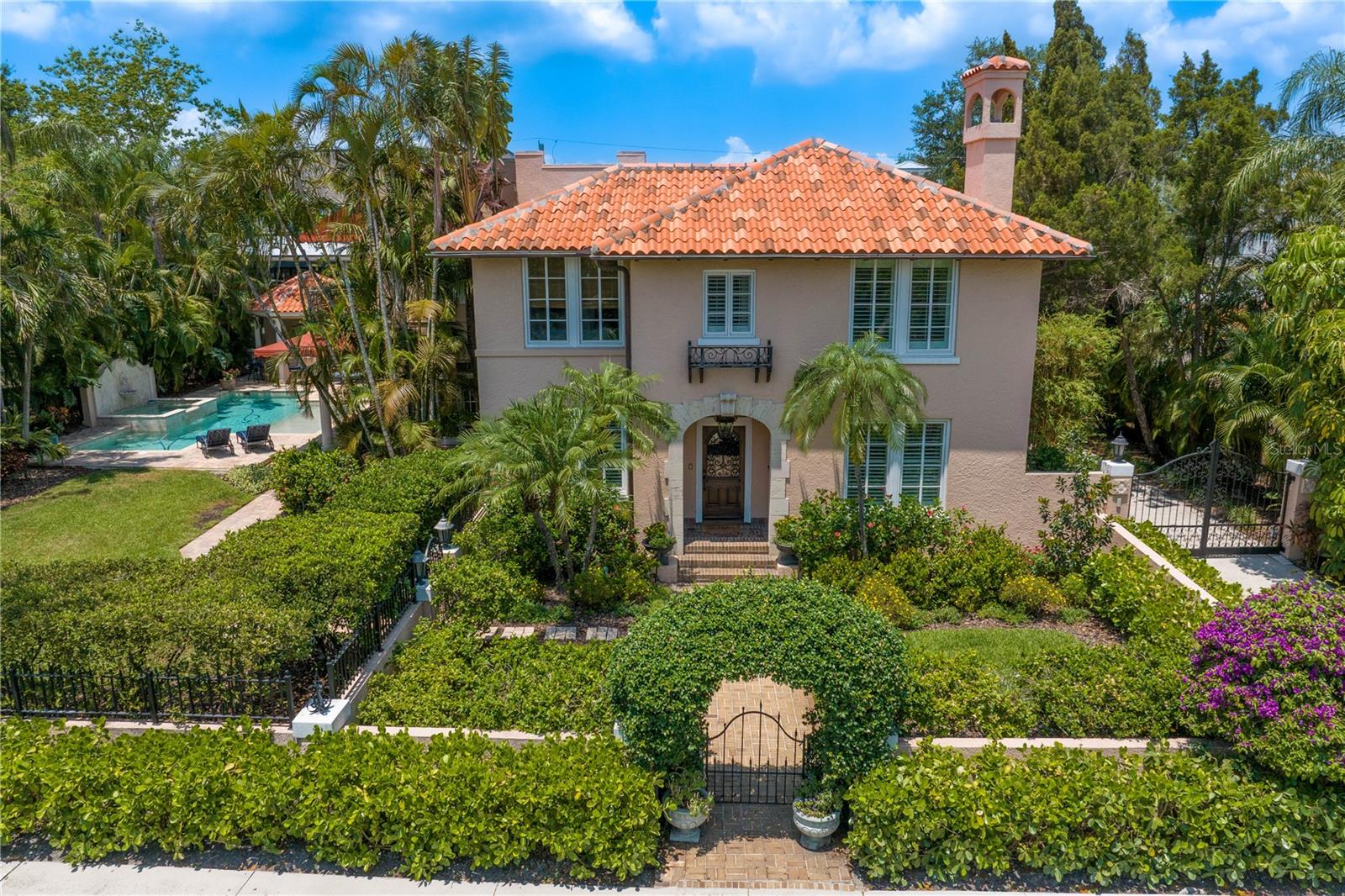 Located on desirable Davis Islands, built on a crawl space and surrounded by a block wall fence, this historical home has been kept high and dry, with no water damage to the interior. This stunning Mediterranean residence was one of the original homes built in 1929. This 5,566 square foot property maintains all of the original character, while offering updated touches throughout. Many features have been restored to their original state including the front door, gates leading to the kitchen, a leaded window, original staircase, built-ins, and many of the floors. The Formal Living Room (14' X 20') features a wood burning fireplace, plantation shutters and original hardwood floors. Across the hallway is a bright Den/Office (12' X 14') equipped with built-ins, plantation shutters and original hardwood floors. A 1/2 bath can be found tucked in under the stairs. The oversized gourmet eat-in Kitchen (25' X 25') is the hub of the home. There are 2 islands with 3" countertops. This Kitchen is a chef's dream complete with a 6-burner Thermador range top with griddle, Thermador double ovens, a Bosch dishwasher, 2 warming drawers, 2 refrigerated beverage drawers, commercial grade Sub Zero refrigerator and freezer, microwave, ice maker, wine cooler, walk in pantry and appliance garage. There is also a built in desk and 2 sets of French doors that lead to a gated motor court, 2 car garage and storage shed/workshop. The Great Room (32' X 25') is expansive and has a built in custom entertainment center. The room is also wired for indoor and outdoor surround sound. Just off the Great Room is a hallway with a 5-locker Mud Room and a two story in-law suite. The upstairs (13' X 21') can be used as a playroom/office/bedroom. Downstairs houses a full bath, indoor utility room and extra storage cabinets. Upstairs, the Primary Suite (32" X 25') features plantations shutters, a large built in armoire and French doors opening to a long, covered terrace overlooking the large yard and pool. The Master Bath has a soaking tub, separate shower, his and her sinks, his and hers laundry pullouts and his and hers custom walk in closets. The 2nd floor also houses 3 other bedrooms. The second bedroom (14' X 14") has the original hardwood floors, a walk in closet, the home's original dining room chandelier, and an en suite bathroom with a stand up shower. The large third bedroom (16' X 14') has 2 custom closets, plantation shutters and the original hardwood floors. The fourth bedroom has a walk in closet and the original hardwood floors. The third and fourth bedrooms share a completely remodeled Jack and Jill bathroom with a stand-up shower. Back downstairs, 3 French doors lead from the Family Room to the outdoor entertainment area. There is a sizable lawn, lanai, pool with fountain, sun shelf and hot tub. The pool cabana is complete with a wet bar and a full kitchen. A mosquito misting system keeps the perimeter of the house bug free. The property also has an in ground irrigation system, and outdoor lighting illuminates the entire yard. The exterior also has been recently updated. The entire home was painted, and custom made awnings were installed in 2021.
