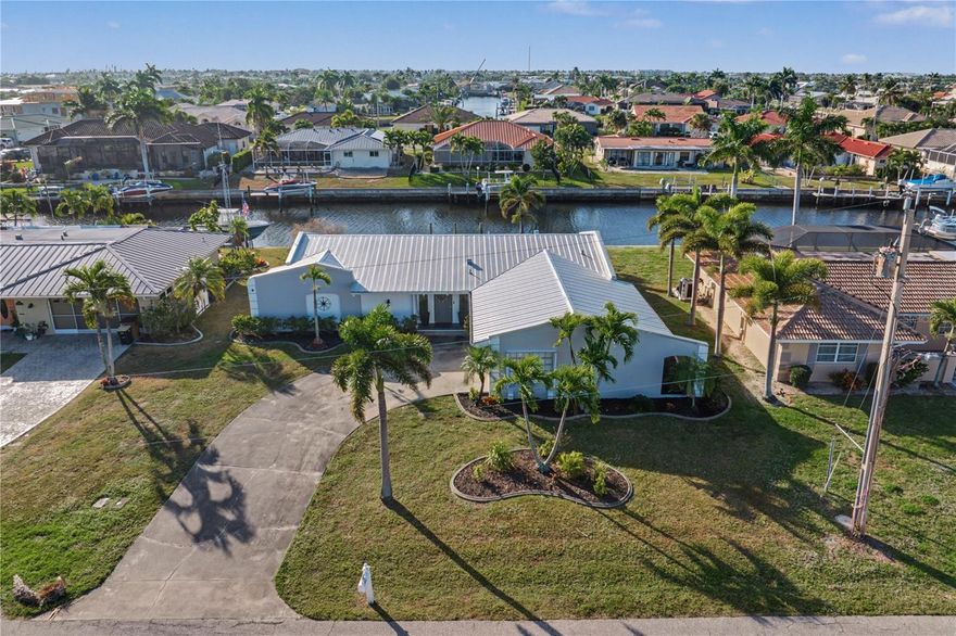 NEWLY RENOVATED PGI WATERFRONT HOME W/82 FT OF SEAWALL, SOUTHERN REAR EXPOSURE & QUICK BOATING ACCESS - Enjoy the Punta Gorda Isles lifestyle from this updated, move-in-ready, 3 beds/2 bath waterfront home. Set along a wide canal with 82 feet of seawall, the property delivers access to open water in under 15 minutes from your backyard. Inside, the open-concept floor plan flows seamlessly from the living room to the dining area and kitchen. Luxury vinyl plank flooring, recessed lighting, and neutral finishes create a bright, cohesive space ideal for entertaining or relaxing. Large sliding glass doors frame the water view and connect the interior to the screened lanai, reinforcing true Florida-style indoor/outdoor living. The updated kitchen features white shaker cabinetry, quartz counters, NEW stainless steel appliances, and an oversized peninsula with seating that acts as the natural gathering point of the home.  The dining area sits conveniently between the kitchen and living room, offering flexibility for casual meals or hosting friends and family. The master suite boasts private lanai access and canal views, creating a calm, comfortable retreat. The renovated master bath includes a walk-in tiled shower, modern vanity, and updated fixtures. Two additional guest bedrooms and a full guest bath provide space for visitors, hobbies, or a home office. Out back, the southern rear exposure keeps the screened lanai sun-filled throughout the day. The backyard offers room to add a dock or pool if desired, while the wide canal view sets the stage for boating, kayaking, or simply enjoying the waterfront setting. Recent improvements provide peace of mind and modern appeal, including a NEW metal roof (2023), NEW LVT flooring (2025) throughout most of the home, NEW A/C system (2025), updated kitchen and primary bath (2025), and a NEW water softener (2024). Other amenities include whole-house hurricane protection and an oversized two-car garage. Located in Punta Gorda Isles with no HOA, optional membership to the PGI Civic Association offers social clubs, activities, and community events. Miles of sidewalks connect to St. Andrews South Golf Course, Fishermen’s Village, downtown Punta Gorda, and the Ring Around the City walking trails. Make an appointment today and take advantage of the boating and active waterfront lifestyle that make Punta Gorda Isles so desirable.
