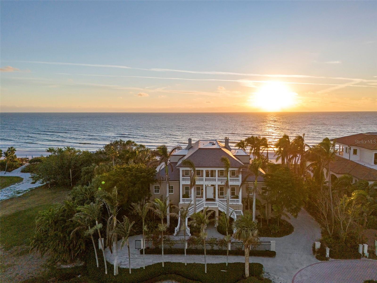 Welcome to a truly remarkable legacy estate spanning 150’ of walking beach tucked behind the gates of the exclusive Longboat Key Club in Regent’s Court. Unquestionably, one of the area’s most distinguished and desirable locations. Perfectly positioned on a quiet street, this custom built residence offers unparalleled views of the Gulf of Mexico, lush tropical landscaping, and is designed for the ultimate Longboat Key lifestyle. Boasting 5-bedrooms, 5.5-bathrooms, the home is a masterpiece of traditional island-style design, featuring soaring ceilings, exquisite trim, and detailed moldings throughout. Expansive verandahs overlooking the Gulf create seamless indoor-outdoor living spaces, perfect for entertaining or simply savoring the tranquil surroundings. Quick access to the beach with a walk-over shared with your neighbor.
Greet your guests in a formal and elegant gallery, with exceptional views of the Gulf of Mexico. A lovely music room off the gallery is reminiscent of a gentler time when entertaining guests was an artform. The formal dining room complete with exquisite built-in alcoves is perfect for a five-course dinner party with a butler’s kitchen conveniently located for service. The large kitchen with oversized informal dining area features two chandeliers. The island bar provides additional casual seating. A wet bar with sink and wine storage, gas range, microwave, built in oven and Sub-Zero refrigerator make cooking a delight. A large family room with built in shelves is the perfect place to gather with family and friends. A beautiful office with custom wood built-ins, cozy fireplace and plantation shutters provides a quiet spot to work, read or simply enjoy the views of the water. The spacious first floor owner’s suite is a private retreat unto itself, offering two separate bedrooms and bathrooms and spacious custom closets. Four additional second floor guest suites provide plenty of room for guests or family. An additional family room with fireplace and built in bookshelves opens onto the verandah for viewing sunsets. The resort-style tropical pool and hot tub are framed by a spacious patio, surrounded by lush greenery that ensures privacy and serenity. The walkway to the beach is conveniently located near-by. This home is perfect for the car enthusiast with room for 8 cars in the garage and lots of storage including an elevated enclosed climate-controlled storage room. For convenience, an elevator provides easy access to all levels of the home. Whether relaxing on the verandahs, hosting gatherings by the pool, or enjoying the serenity of the Gulf, this estate embodies the finest in elegant beach front living. Don’t miss the opportunity to own this prestigious Regent’s Court estate home.