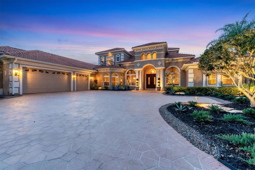 Welcome to luxurious living in Lakewood Ranch Country Club. This stunning five-bedroom, 5.5-bath estate boasts 5,814 square feet of living space and is sure to impress. As you enter the heavy wood door with intricate design, you are greeted by a foyer with a high ceiling and beautiful dome, an arch with columns and decorative tile flooring. The living room features a two-story coffered ceiling with custom molding and trim, a two-story fireplace with custom built-in shelving and mirrored alcove, and a wall of large windows offering picturesque views of the golf course and lanai. The wet bar is ideal for entertaining, with a beverage cooler, prep sink and bar seating, all surrounded by wood cabinets and quartz countertops. The dining room is elegant and spacious, with a mirrored wall with column detail, custom high ceilings with artistic detailing, an enormous window with plantation shutters and decorative tile flooring. The den, near the living and dining rooms, features built-in shelving and cabinetry, an enormous window with plantation shutters and custom wall trim. A two-stop elevator is conveniently near the grand staircase for easy access to the upper level. The kitchen is a dream, with granite countertops, newer Monogram® appliances including two dishwashers, a range with six burners and pot filler, a vent hood, an oversized refrigerator and freezer, an island with a prep sink, a hidden pantry, custom cabinetry, dry bar and a breakfast nook with an aquarium window. The adjacent family room offers a built-in entertainment center, a built-in workstation with custom organization and two sets of pocketing sliders that open to the lanai, seamlessly blending indoor and outdoor living. The lanai is an oasis, with a paver pool deck, an outdoor kitchen with an infrared grill, beverage cooler, sink and quartz countertop with seating, a stone fireplace and a sitting area wrapped in arched columns with their own screens. The saltwater pool and spa feature a cocktail table within and a sun shelf. The outdoor space also offers multiple covered and uncovered living and dining areas, all surrounded by lush landscaping. The primary bedroom suite is a retreat, with an alcove entry, tray ceiling with custom crown molding, a sitting area with large windows and plantation shutters, and a private entry to the lanai. The luxurious bath is complete with a private water closet, Roman shower with three shower heads and bench, an exquisite vanity with two sinks and a seating area all with marble countertops, a Jacuzzi tub and custom tile design on the floors. The grand staircase leads to the second-floor bonus room, ideal for entertaining, with a kitchenette, bar-height seating, custom built-ins, crown molding, zero corner sliders, windows with plantation shutters, custom trim accent wall and a spacious screened-in terrace. The second level also features a guest bedroom with its own private balcony and a shared bath. The two downstairs guest bedrooms are spacious and elegant with their own en-suite baths. The office, in the downstairs guest wing, features an en-suite bath and can also be a guest suite. The three-car garage has an overabundance of storage plus an enclosed room for a workshop. Lakewood Ranch Country Club is conveniently near Lakewood Ranch Main Street, Waterside Place, shopping or dining at UTC, easy access to Interstate 75 and a short drive to beautiful beaches. You won't want to miss this opportunity!