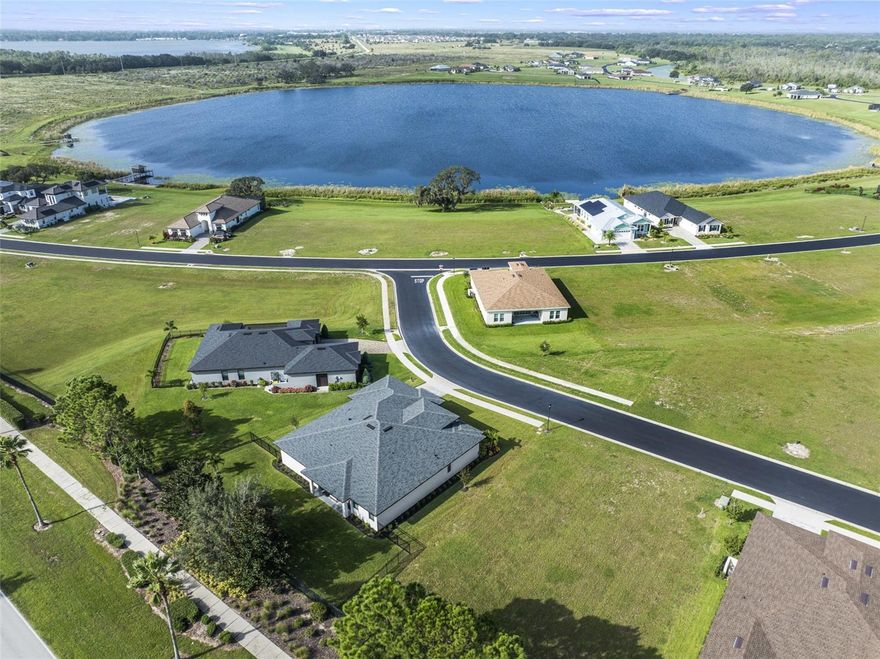 Now offered at $709,900 with a rare 4.875% ASSUMABLE mortgage rate - offering significant monthly savings compared to today's rates. Built in 2023, this custom lake-access residence offers over 3,000 sq ft of single-story living in a gated resort-style community with access to two ski lakes. Welcome to modern living in the sought-after gated community of Water Ridge in Auburndale, where every home is CUSTOM CRAFTED and every view is a postcard! This 2023 BUILT single story **4 bedroom // 3 full bath // 2 offices + theater room** showstopper sits on a large .27 ACRE LOT with gorgeous WATER VIEWS and is packed with modern UPGRADES, smart tech, and access to RESORT STYLE AMENITIES. Step inside and fall in love with the bright OPEN FLOOR PLAN, high ceilings, and LUXURY VINYL PLANK flooring throughout. In addition to four generous bedrooms, this home also delivers two dedicated office spaces, a TOP-OF-THE-LINE THEATER ROOM, and three full baths – perfectly designed for everyday comfort and elevated entertaining. At the heart of the home, the home chef’s dream kitchen stuns with a massive 13’ QUARTZ ISLAND with a WATERFALL EDGE, built-in wall oven, stylish solid wood cabinetry topped with crown molding, an abundance of drawer and cabinet storage, and sleek pending lighting. The SAMSUNG FAMILY HUB REFRIGERATOR is a functional showpiece and the TP-Link Deco Whole House Mesh System (5 nodes) keeps everything connected. The living room impresses with a BUILT-IN MEDIA WALL featuring 100" TV with Surround Sound System (included with sale), a dramatic 72” ELECTRIC FIREPLACE (2024), and a modern fan, all anchored by a wall of sliding glass doors that open to the COVERED LANAI and FULLY FENCED backyard beyond. The SPLIT BEDROOM layout provides privacy, while your PRIMARY SUITE delivers fresh, modern vibes with luxurious finishes and a spacious en-suite retreat. Residents should know, Water Ridge isn’t just a neighborhood – it is a lifestyle! You will enjoy access to 3 LAKES, 5 GATED ENTRANCES, 3 BOAT DOCKS, boat trailer storage, and 3 POOLS (two leisure, one lap). The clubhouse, fitness center, men’s and women’s saunas, sports courts, and pickleball and tennis facilities make every day feel like a vacation. Plus, with onsite HOA management, the community is as well maintained as it is beautiful. Whether you are seeking privacy, luxury, or an active lakefront lifestyle, Water Ridge offers it all just minutes from major highways and central to everything in Polk County. Call today to schedule a tour!