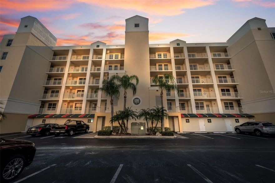 Welcome Home to Your Luxurious Oasis! Discover the ultimate in resort-style living with this highly sought-after luxury condominium, perfectly positioned to offer stunning lakefront and golf course views. Nestled within one of the best-kept secrets in town, this meticulously maintained community presents an exceptional 2-bedroom, 2-bathroom residence featuring 1,320 sq ft of sophisticated living space. From the moment you step inside, you’ll be captivated by the open and inviting ambiance created by an abundance of natural light. The seamless tile flooring flows gracefully through the main living areas with carpet in the bedrooms, while elegant crown molding and soaring high ceilings provide the luxurious touch you've been seeking. This unique unit includes a custom-built office desk in the kitchen corner—an exclusive feature not found in other residences within the community. Across the space, custom shelving and cabinets enhance functionality and style, perfectly complementing the kitchen, which comes equipped with a newer Bosch dishwasher, newer refrigerator, ample cabinet space, and a convenient closet pantry for all your storage needs. Retreat to the primary suite, a sanctuary of comfort that includes two spacious walk-in closets and a luxurious en-suite bathroom featuring dual sinks. Enjoy direct access to the lanai, creating a perfect escape for morning coffee or evening relaxation. Additional highlights include a dedicated laundry closet with a washer and dryer for effortless convenience, a 3-year-old A/C unit, 3 -year old water heater, and a freshly painted interior (completed in 2024). The new front screen door adds an extra touch of elegance as you enter. Open the sliding glass doors from the living room to your expansive screened-in lanai, complete with remote-controlled custom shutters to adjust your views at will. Experience breathtaking sunsets over the tranquil lake and lush golf course, making every evening a picturesque retreat. This unit includes a private parking spot right next to the elevator, ensuring easy access along with an extra allowable parking space. The building’s orientation offers some of the best views in the community, enhancing your lifestyle experience. Community amenities are second to none, featuring a resort-style heated pool and spa, a clubhouse complete with a full kitchen, meeting room, library, and a cozy lounge area for gatherings. With a reasonable HOA fee of $672 per month, you can rest easy knowing it covers water, trash, sewer, cable/WiFi, amenities, building insurance, and exterior maintenance. This well-funded HOA boasts healthy reserves and no outstanding SIRS issues. Pet lovers will appreciate that 2 small dogs are permitted for owners, and rental options are available with a minimum 3-month commitment. Enjoy low-maintenance living, also just steps away from the East Bay Golf Club and the building is directly across from the community pool and clubhouse. Ideally located just minutes from the exquisite beaches of Pinellas County, and close to shopping, dining, and entertainment, with easy access to both Tampa and St. Pete Clearwater airports—just under 30 minutes away. Don’t miss this opportunity to own a slice of paradise where luxury meets convenience! Welcome home!