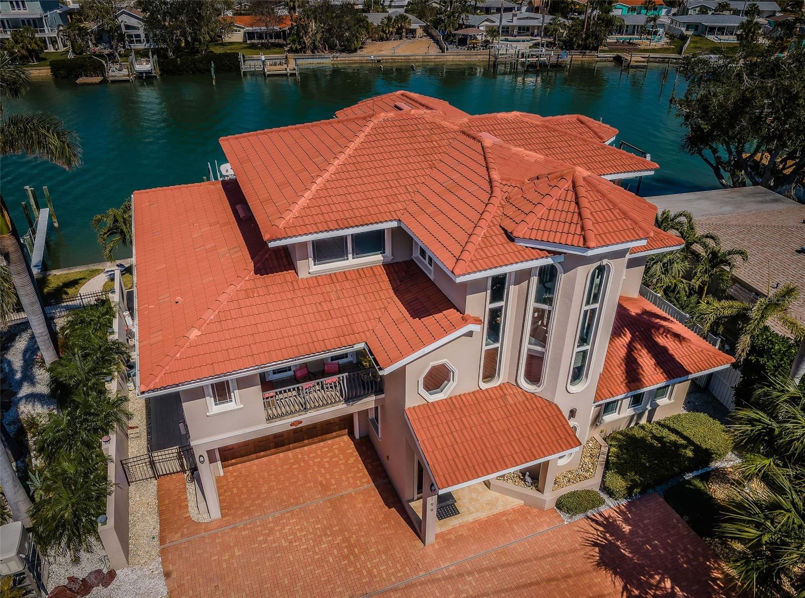 BUILT-TO-LAST WITH ALL BLOCK CONSTRUCTION, THIS SUPERB WATERFRONT RESIDENCE IS A SHORT WALK TO PASS-A-GRILLE BEACH AND JUST A FIVE-MINUTE BOAT RIDE TO THE GULF! Beyond the electronic gated entry and attractive brick paver driveway, you’ll discover an impressive 5-bedroom home with 4766 sqft of elegant living area. With its first living level built above base flood elevation, you’ll love walking straight out to your pool deck and waterfront paradise. First level provides a large casual living and dining space, along with a mini-kitchen, bedroom, luxury bath, bonus room and plenty of storage. Driftwood-style porcelain floors and splendid wainscot finishes introduce the sumptuous 2nd level, with its grand 17ft-high living room overlooking the water, and access to a well-appointed 300 sqft cover waterfront balcony with fine ceilings and flooring, and access to a second south-facing balcony. Richly-finished kitchen boasts leather-like granite surfaces, butcher block island prep center, two breakfast/casual dining bars, stainless-steel appliances and gas cooking. The wonderful waterfront dining space offers fabulous water views and balcony access. Sizable guest bedroom suite overlooks the waterfront, has private access to the waterfront balcony, and includes an alluring full bath with exceptional walk-in shower. 2nd guest bedroom delivers an inspiring coastal chic appeal while the 3rd bedroom is generously-sized and overlooks the water; both bedrooms are supported by a beautifully-tiled full guest bath. Your upper level contains a fabulous built-in office area and the lovely waterfront owner’s suite with posh morning bar, built-in waterfront seating/storage bench, dedicated washer/dryer closet, walk-in closet, and a private 200sqft balcony overlooking the water with views of Pass-a-Grille. The lavish owner’s bath boasts exquisite tilework, dual vanities, granite surfaces, a jetted spa tub and a gorgeous walk-in shower with matching tilework. Step out back to the 1st level 315sqft covered waterfront lounging and dining area that transitions to the stunning Pebbletec Pool and Spa - all supported by a terrific shellstone paver deck. Updated seawall and composite dock on deep, protected water support 20,000 lb and 13,000 lb boat lifts, both with catwalks. Long list of value-added extras includes a 3-stop elevator with window, large-capacity propane tank, whole-house water filtration/softening, newer AC units, epoxy garage flooring, and much more. Equally important, flood insurance is just $950/yr! An outstanding value in a prime boating/beach location! Dimensions are estimated, buyer to verify.