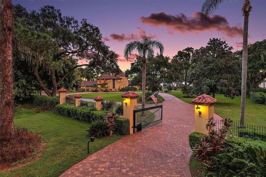 Gently tucked away in the impressive Squirrel Point subdivision, this gated Spanish Mediterranean estate looms majestically on just under 4 acres of tropical paradise. It is a true sanctuary, offering 900+/- feet of Lake Dora shoreline and breathtaking views that will transport you to a world of tranquility. As you enter the property, you will be captivated by the enchanting panoramic scenes unfolding before you. The Tavares and Mount Dora skylines paint the horizon, while spectacular sunrises, sunsets, and moonlit evenings create a magical ambiance. Imagine the Dora Queen passing by, or the mesmerizing display of holiday fireworks lighting up the night sky - all visible from almost every angle of this incredible property. Step into the grandeur of the residence through the dramatic foyer entry, where an impressive grand staircase and soaring 21-foot ceiling welcome you. The sparkling stained glass windows add a touch of elegance, casting colorful hues as the sunlight streams in. Designed with entertaining in mind, this home boasts a formal dining room, a spacious 40x22 family room with an elegant stacked-stone fireplace, and a wet bar. The refreshing in-ground pool and outdoor terraces invite you to relax and soak in the beauty of your surroundings. Retreat to the second-level Owner's suite, a romantic haven adorned with an impressive brick-surround gas fireplace—French doors open to the Owner's private balcony, offering captivating views of the waterfront. The Owner's en-suite bath has been meticulously renovated, exuding an unmatched level of elegance and sophistication. Additional living spaces include a secondary owner's bedroom with a private en-suite on the main level and two other bedrooms with a Jack and Jill bath. For guests seeking their own oasis, the 2/1 guest house provides a cozy interior, stunning views of Lake Dora, and an additional 3-car garage for additional golf cart or boat parking. Sitting on the shoreline of Lake Dora, the 36x40 boathouse is a true gem. Complete with a kitchen and plenty of room for entertainment, it offers the perfect spot to unwind and take in the serene beauty of the surroundings. You can watch seaplanes gracefully glide across the water from the comfort of your screened boathouse porch while sipping your favorite cocktail. And if you've ever dreamed of landing your own seaplane on your doorstep, this secluded retreat can make that dream a reality. This property is not just a home; it is an extraordinary experience. Every detail, from the meticulously landscaped grounds to the private and serene ambiance, has been thoughtfully crafted to create a truly magical oasis. Discover this hidden gem and indulge in the beauty, privacy, and luxury that awaits you!