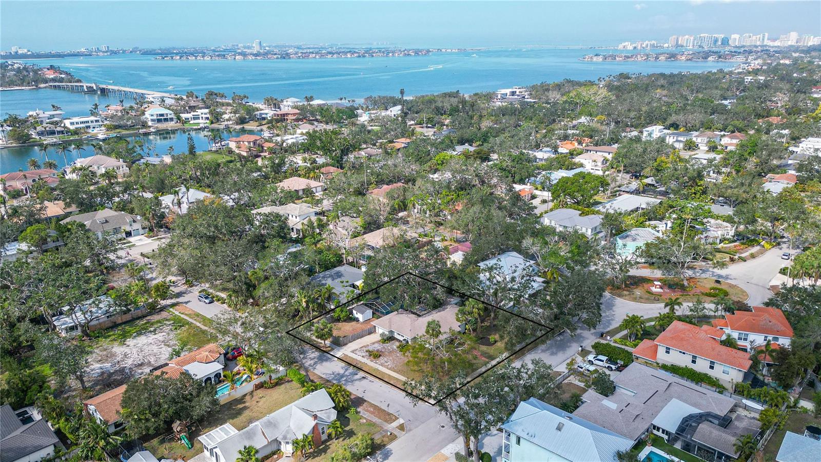 Discover a rare, expansive property nestled in one of Sarasota’s most coveted “West of Trail” neighborhoods. This .35-acre property sits gracefully above special flood zones and offers convenient access to Downtown Sarasota, Siesta Key, and the prestigious Field Club. Located within the esteemed Southside Elementary School District, this home combines the quiet charm of the Granada neighborhood with easy access to Sarasota’s growing attractions. Follow the winding red brick path inside to a welcoming living room featuring a wood-burning fireplace and cozy atmosphere. The updated kitchen boasts quartz countertops, custom cabinetry, and sunlit views across the serene back courtyard. A distinctive sitting room with tongue-and-groove ceilings, a café dining area, and a peaceful reading nook overlooks one of the many tranquil courtyard settings. In the primary suite, you will find vaulted ceilings, a spacious ensuite bath, and French doors that open onto a pergola-adorned back deck. Two guest bedrooms—one currently configured as an office—are thoughtfully positioned across the home with convenient access to an additional guest bath. Completing this graceful estate is a generously sized screened pool nestled under mature oaks—a perfect backdrop for leisurely outdoor entertaining. This tranquil courtyard residence may serve as your gateway into one of Sarasota’s most cherished neighborhoods, or its impressive 128 feet of lot frontage could provide a remarkable canvas for your forever home. Enjoy the comforts of mainland living while being just minutes away from the powdery sands of Siesta Key beaches and the cultural attractions of downtown Sarasota.