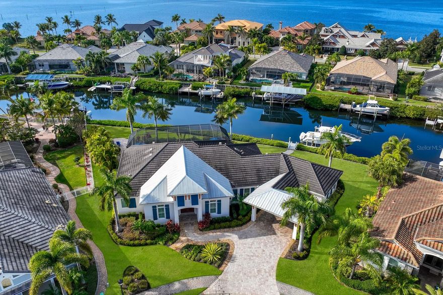 Absolutely stunning custom home on an oversized lot in the gated boating community of Harbour Walk. One of the only homes to have over 200’ of waterfrontage in this prestigious neighborhood situated on the banks of the Manatee River which leads directly to the Gulf of Mexico. This elegant coastal home was custom built by Camlin Homes with the highest attention to detail and no expense spared! Truly a masterpiece that was professionally decorated top to bottom. This luxurious estate sits upon a .36 acre lot surrounded by tropical lush landscaping and over 200 feet of water frontage! Very difficult to find a home that offers this much frontage- bring your yacht! As soon as you walk in the front door you will be struck by the abundant sunlight coming through the house and the soaring ceilings. Impeccable craftsmanship and design are evident throughout the home which offers a timeless combination of interior choices that are featured in Home & Design Magazine. Impact resistant windows and a full-home generator keep your worries at ease. With an open floor plan and exquisite details, this home has a bit of something for everyone including 3 bedrooms, 3 bathrooms, a spacious office/den, a very large extended garage, eat-in kitchen, and extensive outdoor living space. Expansive impact-resistant 10’ sliding doors seamlessly blend the gathering areas with the oasis-inspired surroundings while ushering in natural light throughout. The bright, open-concept living room features 12’ ceilings, beautiful wood floors, and a large entertainment wall. The gourmet kitchen will please any chef featuring timeless choices such as a large island, stylish cabinetry, light countertops, and high-end appliances. Hosting gatherings in this entertainer's dream is easy as you can pocket the massive sliders where you can enjoy indoor/outdoor living and dining alfresco. Outdoors, take a dip in the luxurious heated pool and gather around the full outdoor kitchen. A magnificent paver walkway leads out to the private boat dock with a 24,000lb boat lift where you can enjoy all of your water toys and plenty of fishing. Boats, jet skis, and kayaks are all encouraged and available to have on this saltwater canal. When you are ready to retreat, head straight to the grande primary suite where you will immediately feel peace and relaxation. You will love His & Hers walk-in custom closets, as well as the well-appointed primary bath featuring a soaking tub, dual vanities, and walk-in shower. A large office is also found in the front of the home giving a perfect work-from-home environment. This is a prime location close to I-75, minutes by boat to the Gulf of Mexico with fuel and food stops along the way, world-class beaches, shopping, restaurants, golf courses, and more. This house has it all, so don't wait on this amazing opportunity to make your waterfront dream home a reality!
