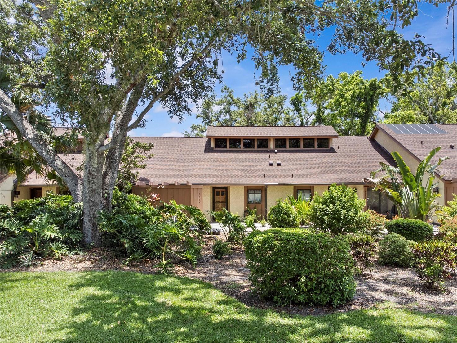 Welcome to this beautifully maintained 2-bedroom, 2-bathroom + loft condo nestled in the lush, tropical community of Pine Bay Forest—just five miles from the white sands of Anna Maria Island and Bradenton’s renowned beaches. This move-in-ready gem offers a rare combination of style, comfort, and resort-style amenities in one of West Bradenton’s most sought-after maintenance-free communities. Step inside to discover an open-concept floor plan with soaring vaulted ceilings, exposed wood beams, and stylish laminate flooring that flows through the living and dining areas. Natural light pours in through energy-efficient, hurricane-rated sliding glass doors with noise-reducing double-pane glass, creating a bright and peaceful ambiance throughout the home. One of the property’s most distinctive features is the custom-built solid pine loft. This elevated space provides a cozy retreat with treetop views, ideal for a home office, creative nook, or additional guest area. The kitchen is light and cheerful, featuring attractive appliances, LED recessed lighting, and a welcoming eat-in area located next to a convenient indoor laundry space. Both spacious master suites offer privacy and comfort, each with large walk-in closets, one lined in cypress and full en-suite bathrooms. Step out to the enclosed Florida room with a thermo-insulated ceiling, upgraded porcelain tile flooring, and outdoor-rated Minke fans—creating the perfect spot to relax and enjoy the surrounding greenery. The private courtyard in the front and a nicely landscaped rear yard offer additional outdoor space to unwind and connect with nature. This home has seen numerous recent upgrades, including a new roof installed in 2022, a brand-new A/C unit in 2024, a refrigerator added in 2023, and a washer and dryer installed just a few months ago. Both the front and rear screen doors have been recently replaced, and the interior has been enhanced with modern lighting and updated flooring throughout. Pine Bay Forest is a quiet, pet-friendly community that offers a host of amenities, including a heated pool, hot tub, tennis and pickleball courts, shuffleboard, and a resident-only nature trail. Take a stroll through the beautifully maintained grounds or spend time at the large community dock overlooking Palma Sola Bay—perfect for watching birds, launching a kayak, or enjoying serene Florida sunsets. Ideally located near Downtown Bradenton, Riverwalk, Robinson Preserve, and Desoto National Memorial, as well as a variety of shopping, dining, and medical facilities, this home is the perfect blend of tranquility and convenience. Whether you’re seeking a full-time residence or a seasonal escape, this upgraded condo is your chance to own a peaceful piece of paradise.