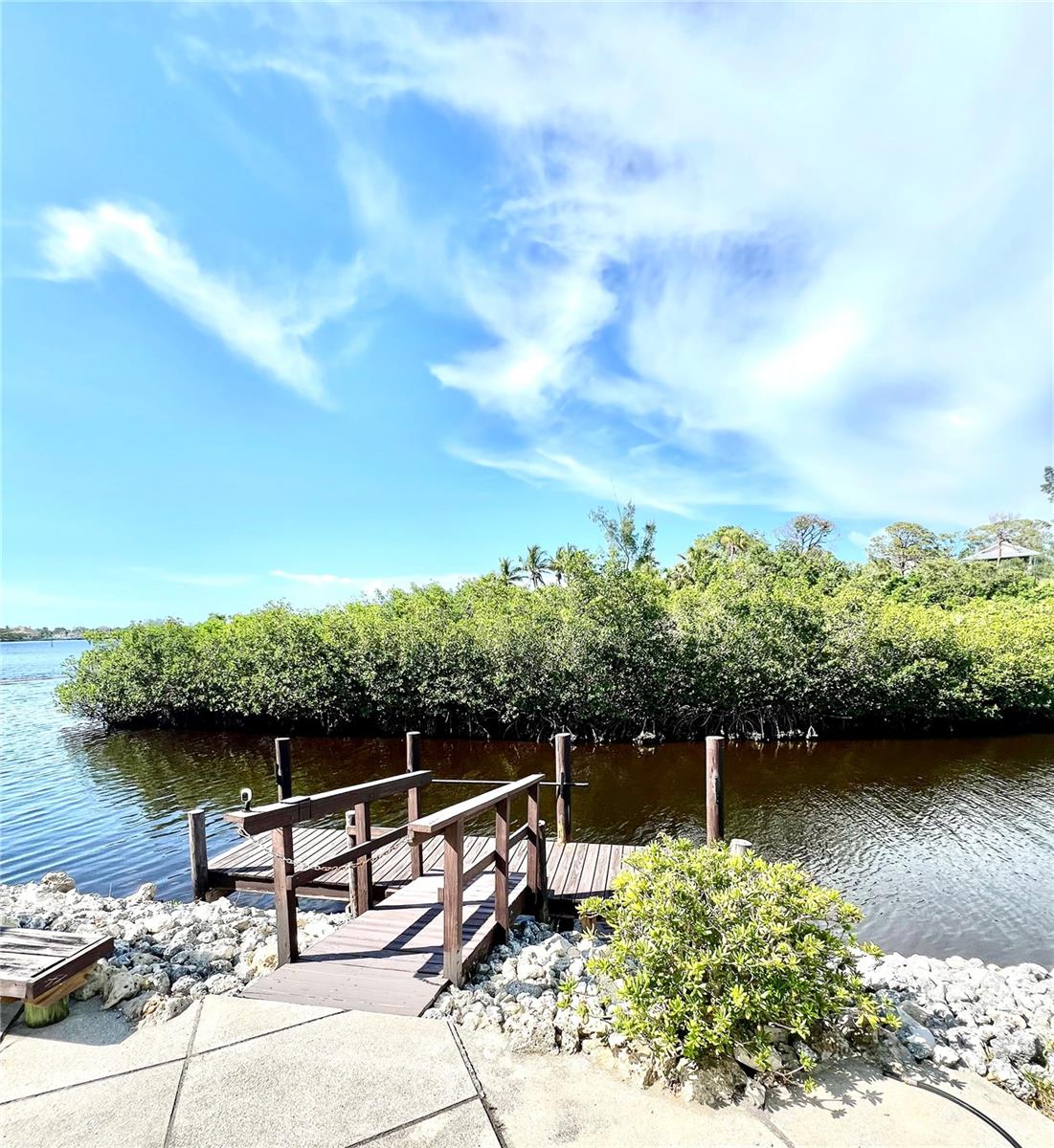 NOW AVAILABLE LONE PALM COTTAGE! Get Ready To Boat, Bike, Run, Swim, Fish! WATERFRONT NORTH VENICE DEAL OF THE CENTURY! Bring your boat, no bridges to the Gulf. Your Very Own Boat Dock!! Community Boat ramp, boat dry storage, boat slips. This lovely bay front sunset cottage has stellar canal and bay views as you walk thru the door. Over 700 sf of open concept living. Living room, kitchen, dining area vaulted ceilings, measures 20X20 stick built, 2x6 construction, built to code, membrane roof, with new impact resistant sliders that offer an expansive canal, mangroves, bay views. Primary bedroom 11X18, built in drawers and three closets and with updated overhead fan light fixture. Butcher block counters in kitchen with newer farm sink. Bathroom has butcher block counters with a walk in shower. Fresh Paint, New Luxury Vinyl Planking, in sand tones. Blank canvas ready for your final touches to make it yours. Turn Key, just bring your boat and suitcase! Welcome to Harbor Lights Cooperative 55+ no lot rent, property taxes, monthly maintenance $250. Fish off your own dock! Must own 2 years before renting. Dock can be rent out. Walk to restaurants, groceries and doctors close by. Tennis, pickle ball, shuffle board, geo thermal pool, clubhouse and Legacy Trail and so much more. Harbor Lights is a 16 acre peninsula surrounded by Roberts Bay and the Intracoastal. Two car inline driveway parking with a storage shed. Seller says sell! Value in land. Milton removed the carport. No interior flood damage.