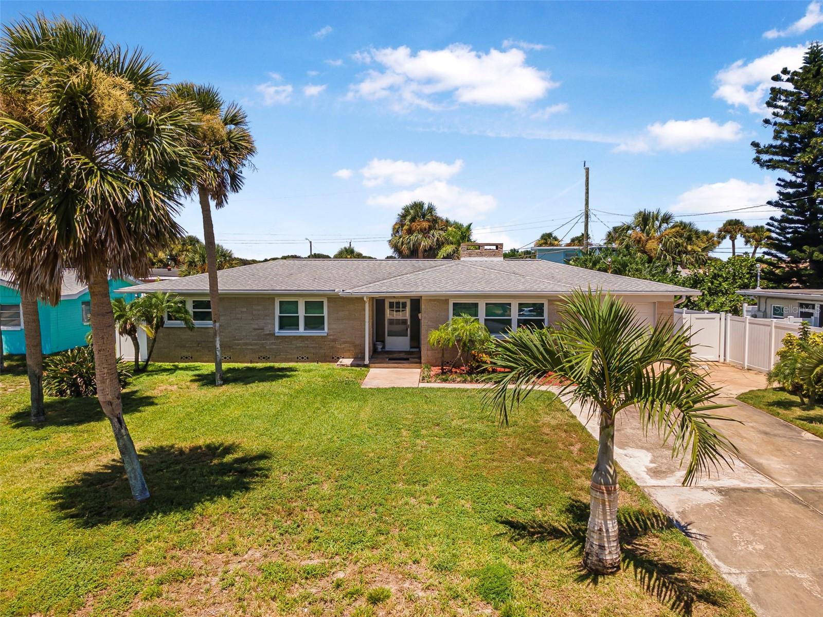 Old Florida lifestyle with guest suite! 2 blocks to the beach and 1 block to the intracoastal waterway. Solid block construction with a low risk flood zone. The well maintained home has a spacious family room, larger kitchen with ample kitchen cabinets, hardwood and stone tile floors, living room fireplace and oversized screened porch. The longer double wide driveway allows for ample parking including space for a boat or RV. Plus a one car garage 24' deep with an additional commode and sink in the garage. Double pane impact windows, 2020 roof, 2023 hot water heater, fully fenced back yard, and all appliances included. Behind the main house is a guest suite 15'x15' with shower, toilet and sink, kitchenette, and 2 Murphy beds. This is ideal for guests, a craft room, The voluntary association owns a fishing dock and boat launch area at the end of the street on John Anderson Drive. Launch your kayaks or boat, or just watch the sunset from the community dock. Community Beach walkover at A1A for a day at the beach. Priced to sell!