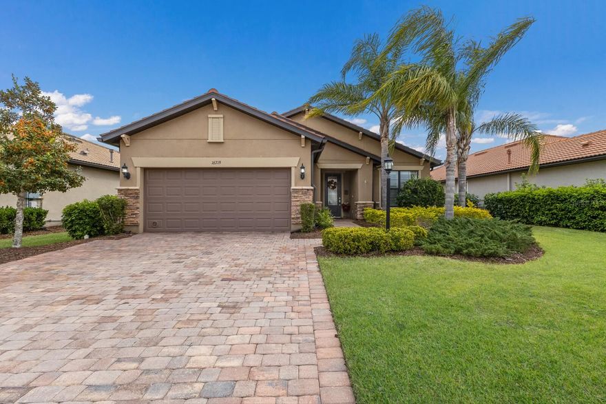 Rare opportunity! This home offers an assumable VA loan (subject to lender/VA approval). Buyer must qualify. Qualified buyers may benefit from favorable terms compared to today’s market. The Good Life Starts Here – Elegant, Stylish & Move-In Ready! Welcome to next-level living in this beautifully designed Martin Ray Model, set in the exclusive Del Webb 55+ community of Lakewood Ranch - the nation’s top multi-generational hotspot. This stunning home is loaded with custom upgrades, stylish design, and resort-style vibes, perfect for buyers who want the ultimate Florida lifestyle without the hassle of maintenance. With 1,964 sq. ft., this home features 2 bedrooms, 2 bathrooms, and a versatile den in an open, easy-flow floor plan. The den is located off the foyer, allowing for privacy and is a space that effortlessly adapts as a home office, workspace, guest retreat, hobby room, or creative nook—whatever you need it to be. This home is beautifully maintained and looks like a model. Interior upgrades include ceramic plank flooring throughout the entire home in a light/neutral color, neutral paint throughout, plantation shutters on all windows and sliders, crown molding and tall baseboards. Designer lighting lends to the home's style and continuity, all of the extra touches create a seamless flow throughout the entire home. Custom built-in drop zone and closet at entry to garage. Built-in cabinets and laundry tub in the laundry room, which is conveniently located close to the primary bedroom. Owner's suite complete with tray ceiling and ensuite featuring a soaking tub and separate shower, walk-in closet and extra storage. Kitchen dreams start here, it is perfect for foodies, entertainers and everyday convenience with a 10-foot island, separate beverage center and a walk-in pantry. Upgraded stainless steel appliances and gas cooktop, premium cabinets with wood range hood, designer backsplash and under-cabinet lighting. Kinetico water filtration system with water softener. Step outside to your backyard and soak up the Florida Lifestyle. Extended screened-in lanai that is plumbed for an outdoor kitchen and extra outside paver patio area perfect for gardening or to simply watch the beautiful sunsets. Widened paver driveway AND don't miss this garage - there is a complete hobby workshop with countertops and double doors to allow golf cart parking inside, pull-down stairs to access upper and lower storage areas, built-in cabinets and small beverage fridge - this is truly a bonus of quality workmanship. Don't miss this one, schedule your private showing today!