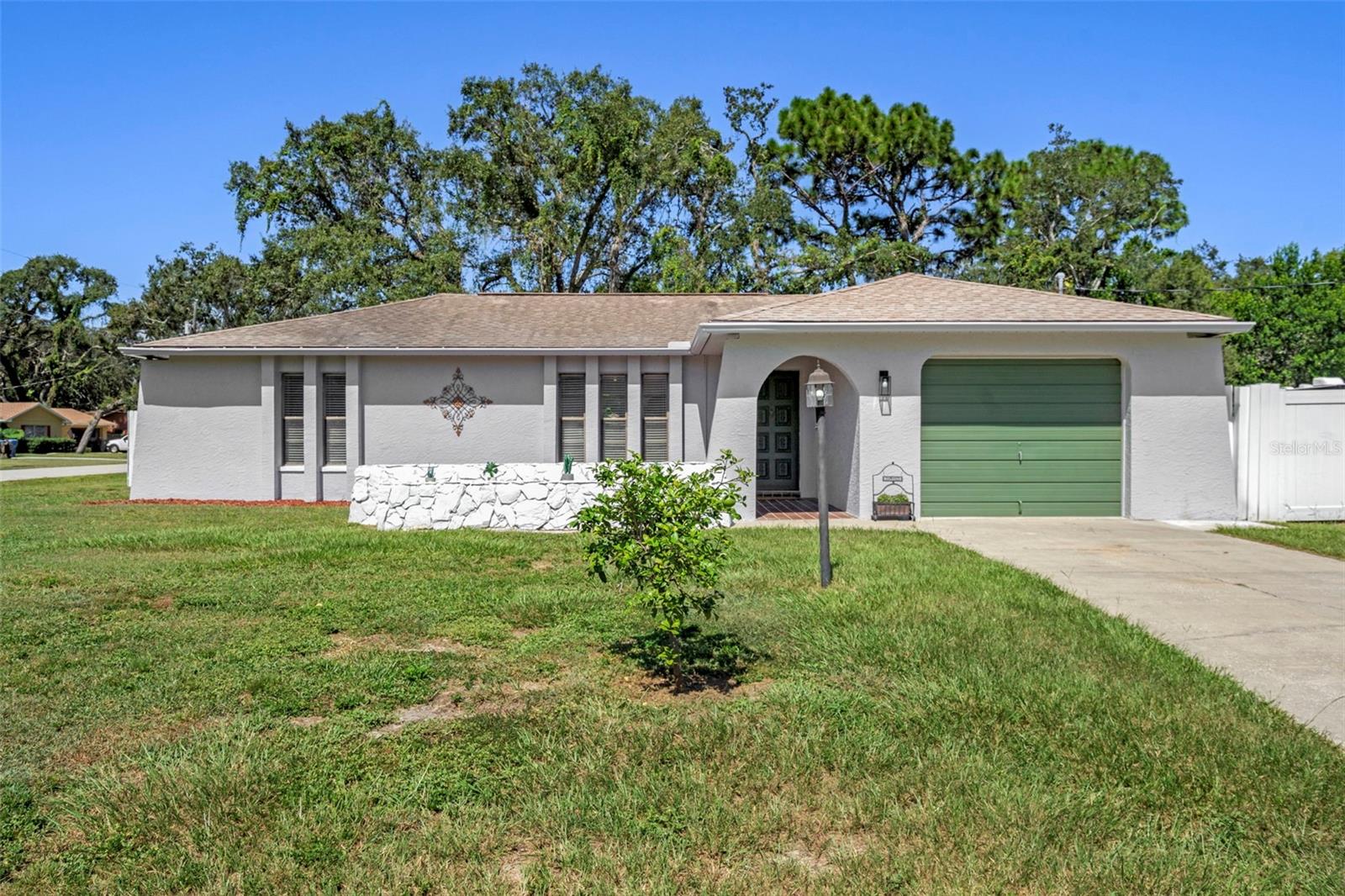 This meticulously maintained two-bedroom, two-bathroom home with a one car garage in Spring Hill offers an inviting and spacious open layout, perfect for comfortable living. The home has a fully repaired sinkhole with all documentation and the home is is fully insurable. Gorgeous ceramic tile flooring runs throughout the home, enhancing its elegance. The formal living room and dining room feature sliding glass doors that seamlessly connect to a huge open outdoor patio, ideal for entertaining, dining outdoors, or enjoying the serene outdoor space. The property boasts a fenced backyard, which includes a large shed that provides ample storage space. A lovely family room features a wood-burning fireplace and flows effortlessly into the kitchen, equipped with two generous pantries for convenience. Additional sliding glass doors lead out to the outdoors, providing a bright and airy atmosphere. Both bathrooms have been beautifully remodeled; the guest bathroom includes a tub-shower combo with gorgeous new tiles, a modern vanity, new mirror, new toilet and new flooring. The second bathroom has a gorgeous step-in shower with new tiles, new toilet, new vanity, new mirror, and new flooring. ensuring a cohesive and fresh look throughout the home. The master bedroom is spacious, complete with a fan light for added comfort, while the guest bedroom also offers generous space and a fan light. Set on a sizable .30-acre lot. The roof will be replaced before closing with durable 30-year dimensional shingles, allowing the buyer to choose their preferred shingle color. The home's exterior has been freshly painted, and the interior has also received a fresh coat of paint, resulting in a move-in-ready space that feels brand new. Don't miss out on the opportunity to make it yours. Priced to sell quickly for only 249,900. Schedule a private tour today and envision your future in this beautiful home—where comfort meets elegance and outdoor relaxation and enjoyment awaits!
