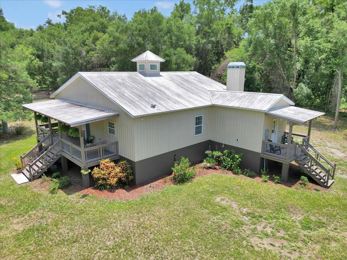 Price adjustment!!! 5 ACRES, mostly cleared. Charming Custom Home looking for new owners!! Welcome to your private slice of Florida paradise! This custom-built home in Weirsdale is truly one-of-a-kind, blending thoughtful craftsmanship with unique details and an unbeatable location near some of Central Florida’s most beloved spots. Bring your animals and have the FREEDOM to enjoy your homestead the way you want. with the PRIVACY you want!! Crafted with steel siding, a metal roof, and surrounded by beautiful mature landscaping and gorgeous TREES this home is built Inside, you’ll find 10-ft ceilings throughout, vaulted ceilings in the main living area, and a 4 window cupola that floods the space with sunshine. Even more natural light streams through solar tubes in the bathrooms—this home absolutely glows! The living room features a cozy wood-burning fireplace with a handmade maple mantle and beautiful stacked stone. The kitchen is a dream—complete with a built-in pantry, tons of cabinet and drawer space, pull-out spice rack, pan drawers, and a waste basket drawer. The butcher block countertops, white shaker cabinets, stone backsplash, and pendant-lit island make this space as functional as it is beautiful. The cabinets are coated with THERMA FOIL making them extremely easy to clean. The oversized laundry/mudroom is a game-changer—with a custom dog wash station, extra storage cabinetry, and access to a covered side porch for added convenience. The primary suite is a true retreat with double barn doors, an oversized walk-in closet with built-in shelving, and a 3x6 tiled shower in the spacious en-suite bath. Set on a partially cleared and partially wooded lot, the property backs up to a lush orange grove and is surrounded by a 9-acre, 34-acre, and 13-acre parcel for ultimate privacy. Laurel oaks and live oaks dot the landscape, and a storage shed with electric and septic plumbing adds extra utility (currently used for RV hookup) Additional Highlights include but are not limited to a Fully fenced perimeter, Large covered front & back porches, security system with cameras, Custom pine doors & craftsman style woodwork throughout, 3-ft wide doorways (excluding primary closet and guest bathroom) for accessibility and Natural light galore! LOCATION, LOCATION, LOCATION! Just a half-mile from the Hope Boat Ramp, you’ll enjoy easy access to Lake Weir for boating, fishing, and waterfront fun. Spend your weekends relaxing at Eaton’s Beach Sandbar & Grill, Gator Joe’s, or Kiwanis Beach, or exploring the natural beauty of Carney Island Recreation & Conservation Area—all just minutes away! Love live music? You're in luck! The Orange Blossom Opry is right up the road and regularly hosts big-name talent like Ricky Skaggs, Craig Morgan, Collin Raye, and The Bellamy Brothers. Lastly the location is close to The Villages and The University of Florida Villages Hospital. What more could you ask for?!
