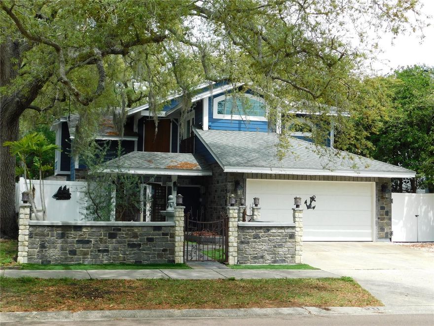 Here is your chance to own Safety Harbor's famous Pirate House! This unique home is located in the heart of Safety Harbor....just a short distance to Phillippe Park, Tampa Bay, schools, and downtown. The owners spared no expense when redoing the exterior of this custom home. From upgrading the siding to installing hurricane rated windows and doors. They also added a double courtyard entrance with a stone wall facade and custom wrought iron gates. Beautiful French doors lead you into a vaulted foyer that is wrapped by a staircase. Ample kitchen with granite counters, stainless steel appliances, a breakfast room with bar and built-ins. There is also a dining area off the kitchen, which leads you outside, through another set of French doors. Spacious Living room is great for entertaining...there is even a spot for an aquarium. In the hall, there is a built in cubby for your little furry friend. Travertine tiles run throughout the first floor. Upstairs...there are 3 spacious bedrooms. The primary has Vaulted ceilings, a walk in closet, a French door opening to a Juliet balcony, a private bathroom with a double vanity, double jetted tub, and skylight. The 2nd bedroom is oversized with a hidden Murphy bed, vaulted ceilings,  pocket door access to the hall bath, and a French door leading out to a balcony that overlooks the backyard. The 3rd bedroom has a custom wall grid system, vaulted ceilings, a French door leading to a balcony and would make a great room to display collections, hobbies, or run a home based business. The hall bath features a walk in shower with a one of a kind, etched glass enclosure. Out back, this home has an expansive patio area with flagstone tile, a hot tub and a treehouse!  The treehouse was built in a way that allows the tree to continue to grow. It has a lookout spot on the roof and a ramp so your furry friend can come visit. Don't miss out on this unique opportunity to live your dream in the coolest house in town!