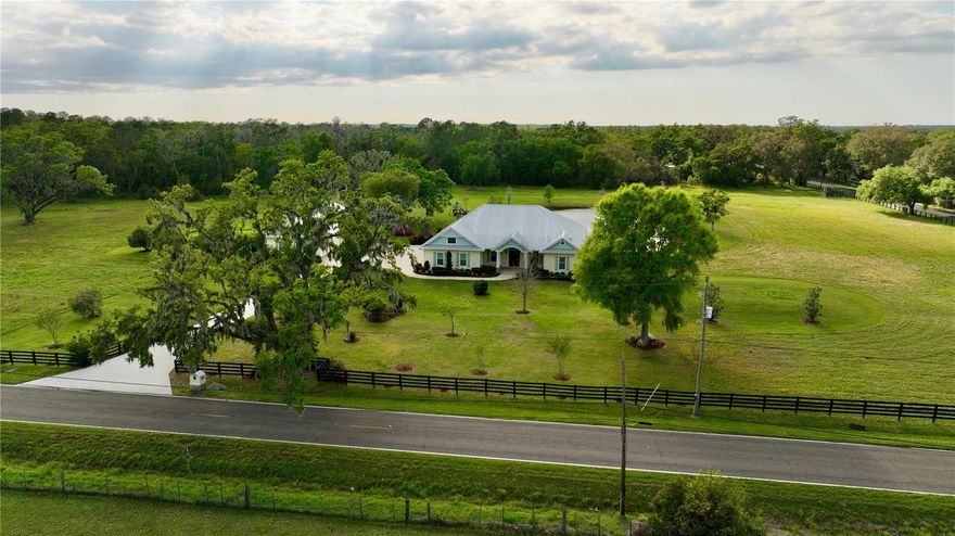 Under contract-accepting backup offers. Enjoy the best of Florida living on an estate with over 24 acres of lush land featuring a custom home plus guest cottage, a pond, a meandering creek, mature trees and the option for agricultural endeavors or subdividing. 
The spacious custom built 3709 sq.ft. home features a split bedroom plan with 3 bedrooms, 3 full baths and has all the finest amenities including an electric security entrance gate, a 676 sq.ft. garage, metal roof, 10' high ceilings, crown moulding, wood floors, custom cabinetry and granite counters throughout. A foyer welcomes you into the home with an executive office on the right, a formal dining room on the left and into the living room ahead with views out to the pond. The kitchen is oversized with stainless appliances, a gas stove, and the island overlooks the breakfast nook and family room with gas fireplace. A large walk-in pantry, butler's pantry and utility room with cabinets and closet provide ample bonus storage space. The primary bedroom has a view of the pond and sunset, a large split closet area with built-in storage that leads to a spacious en-suite bathroom featuring separate vanity sinks with cabinets, a claw foot tub, shower and water closet. The split floorplan includes two additional bedrooms, one with an en-suite full bath and an additional full bath in the hall. The large enclosed screened porch has a finished wood ceiling, ceiling fans, a wet bar, pavers, and overlooks the pond with a sunset view. Just off the pond is a paved area with fire pit, seating and swing. 
The estate also has a lovely guest cottage with 868 sq.ft. featuring a full kitchen, living room, 2 bedrooms, 1 full bath, stackable washer/dryer, a large enclosed screened porch and a 924 sq.ft. garage. 
Property systems include three AC units, tankless on demand water heaters, a generator, a covered well, two septic tanks, and a large pole barn. Both homes were built in 2015. 
The property perimeter is fenced and has multiple gate entrances. The southwest corner of the property is separate, located on the other side of Pierce Harwell Loop. Campbell Branch creek meanders along the southern edge of the property.
The property is approximately 23 miles to Tampa International Airport, 20 miles to Tampa General Hospital, and 26 miles to MacDill Air Force Base.