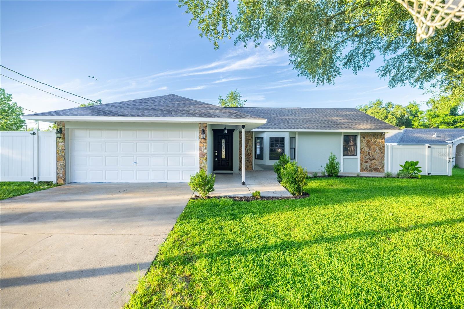 Nestled on a fully fenced quarter-acre lot just off SE Maricamp Road in southeast Ocala, this beautifully reimagined 1,671?sq?ft, 3-bedroom/2-bath ranch home is completely turnkey. The entire interior was modernized with a brand-new roof installed in 2025, an upscale granite-and-stainless steel kitchen, all-new baths, plumbing fixtures, flooring, and energy-efficient lighting and HVAC. Practical upgrades include a tankless water heater, pre-wired for a whole-house generator, new well pump and pressure tank (2024), plus a new septic & leach-field. Outdoors, a durable vinyl fence encloses the yard, which features two storage sheds, low-maintenance landscaping, and ideal space for play, pets, or future improvements. This home offers unmatched location convenience—just minutes from Maricamp’s shops, eateries, schools, medical offices, and Downtown Ocala—while also providing easy access to Silver Springs State Park, Florida’s original tourist attraction, renowned for its glass-bottom boat tours, scenic springs, and miles of trails through a pristine watershed. Plus, Ocala is proudly branded the “Horse Capital of the World”, thanks to its high concentration of equine farms, breeding centers, and national-level competition venues?. With no HOA or age restrictions, this is more than just a home—it’s a smart lifestyle investment offering comfort, convenience, and optional space to grow.