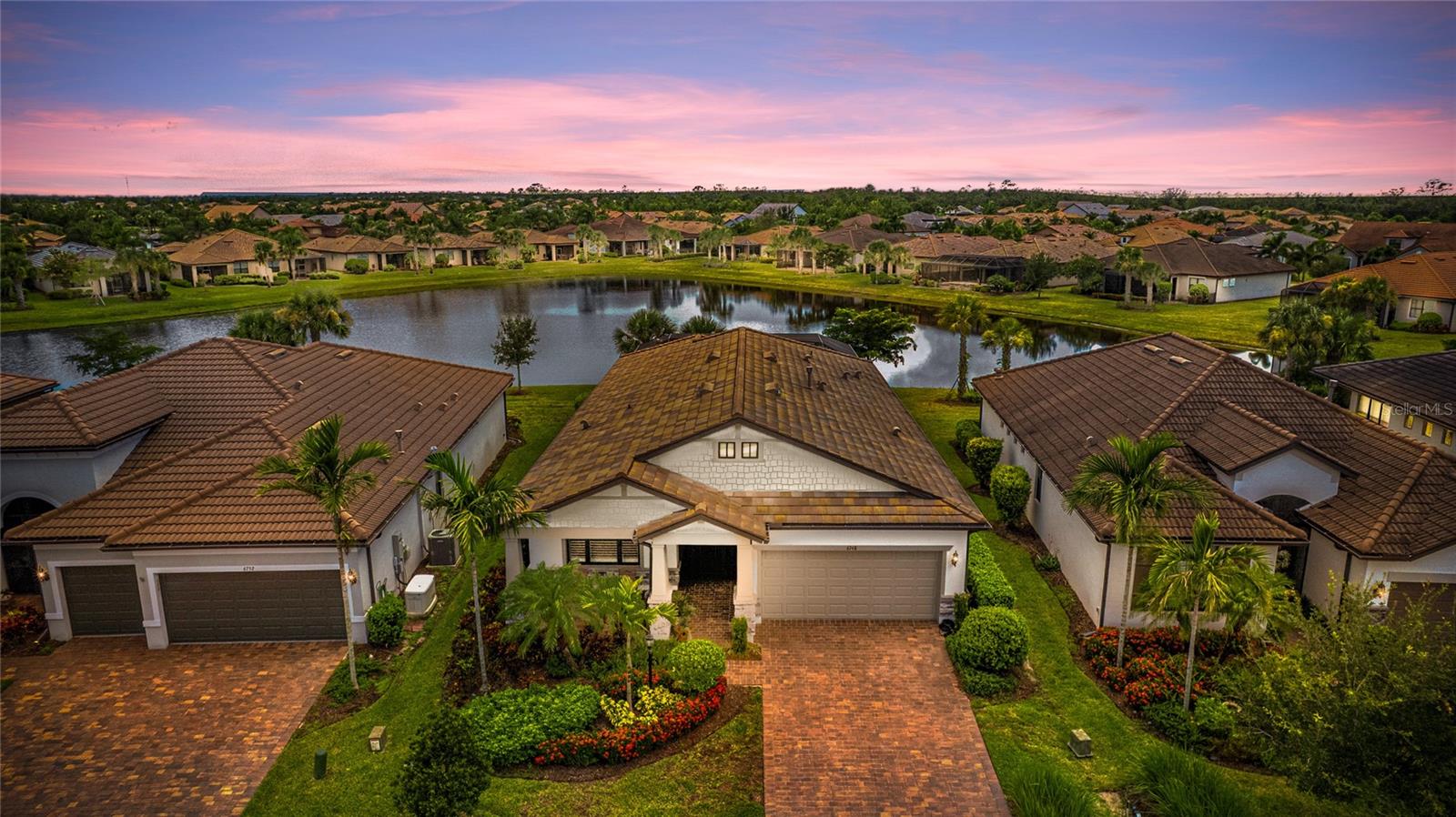 This highly desirable Summerwood Model pool home is immaculate and loaded with over $250K in designer top-of-the-line upgrades. Take comfort knowing you're situated on an incredible water lot within the highly sought after 55+ Del Webb village in the #1 award winning master planned community in the US, Lakewood Ranch. The exceptional layout of over 2000 sq. ft including a versatile den with glass French doors, relaxing sunroom and spacious guest suite provide ample space to spread out and entertain family and guests. The expansive gourmet kitchen is a chef's dream, complete with stainless steel appliances, gas cooktop, and a large eating space. The stunning subway tile backsplash complements the neutral quartz countertops and 36” cabinets with soft-close drawers and pullout shelves, while the generous island provides end-cap storage cabinets and seating for four. Retreat to the luxurious master suite complete with magnificent water views and an ensuite bathroom with dual vanities, large walk-in shower, and a soaking tub. Find lots of storage in the master closet with a custom oversized closet system complete with wood drawers and shelving. Thoughtfully designed custom built-in hall organizer and a dedicated drop zone are conveniently located just off the garage and laundry room—perfect for staying organized as you come and go. Enjoy abundant natural light throughout the home, thanks to the large picture windows in the living room and the sunroom, which is wrapped in windows and filled with sunshine. It’s the perfect spot to relax in air-conditioned comfort while taking in serene views of the pool and pond. The extended screened-in pool lanai is the perfect spot for entertaining guests or enjoying a peaceful evening with your loved ones. Take a dip in the heated salt water pool or BBQ with the built-in outdoor kitchen. Unwind on the charming covered front porch, paved with brick and ideal for enjoying quiet evenings and beautiful sunsets. Enjoy peace of mind with remote-controlled Kevlar hurricane shutters on the windows and lanai that offer not only protection but also double as privacy screens and sunshades, security screened front entrance, and a whole-home generator. Several additional features include an extended garage with space for storage and a golf cart, an oversized laundry room with cabinets, central vacuum system, plantation shutters, 5¼ baseboards, crown molding and surround sound throughout, reverse osmosis system, water softener, in-wall pest system, ceiling fans, rain gutters, and recessed lighting in all rooms. Discover all that Lakewood Ranch has to offer at Del Webb, a resort-style community with an amazing location that is just minutes to several golf courses, theaters, fine dining, hospitals, and lots of world class shopping. This community offers maintenance-free living, a 28,000 sq. ft. Lakeside Clubhouse with restaurant, heated Resort-Style pool and spa, gated security, dog park, and a world-class fitness center. Relax and lounge poolside or enjoy the spacious patio with a fire pit overlooking a lake. Stay active with a full-time activities director, tennis and pickleball courts, bocce ball, and miles of walking and biking trails throughout this highly desirable community. This community has been masterfully designed to offer you the ability to stay active and social. Lakewood Ranch offers the convenience of being centrally located to both Anna Maria Island and Siesta Key with each of their award-winning beaches!