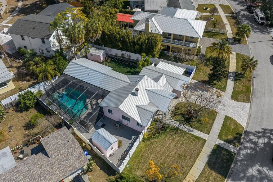 Dunedin Pool Home that truly has it all, with resort-style outdoor living in one of Dunedin’s most desirable locations, beautifully situated on a .23 acre lot. Completely renovated and impeccably maintained, this exceptional Dunedin residence blends comfort, style and effortless indoor-outdoor living. From the moment you step onto the charming covered front porch, you feel it, warmth, quality and intention in every detail. Inside, vaulted ceilings, oak floors, hurricane-impact windows and doors, new interior doors, white faux blinds, and custom closet systems reflect the thoughtful updates completed with care. Offering 3 bedrooms (one currently styled as a home office), 3 full baths and an oversized garage with additional covered parking, the layout is flexible and functional. The living room is cozy and elegant, centered around a natural gas fireplace, perfect for relaxing evenings. The stunning primary suite opens privately to the pool and features a beautifully updated en suite bath with mosaic tile flooring, dual sinks, an oversized walk-in shower and three closets for exceptional storage. The 2023 kitchen is a true showpiece with Harbour Blue KraftMaid cabinetry, black matte hardware, quartz countertops, farmhouse sink, mosaic backsplash, wine rack and a sleek black stainless appliance package all designed for both everyday living and entertaining. A full-size LG washer and dryer are conveniently located in the interior laundry room. Step outside and you’ll discover your own private retreat, truly an extension of the home. A newer heated saltwater pool with spillover 6-person spa (2022) that's fully automated and sits within a screened enclosure. The covered outdoor living space flows seamlessly into a custom outdoor kitchen complete with gas grill, pizza oven, refrigerator, freezer and remote sunshade, perfect for evenings under the Florida sky. A durable metal roof, brick paver driveway, walkway and front porch provide timeless curb appeal and ample parking. Fully fenced with white vinyl fencing and dual gates, low-maintenance turf backyard, drip irrigation on well, natural gas features throughout and two sheds both equipped with electricity. Located in a non-flood zone with no HOA and just minutes to downtown Dunedin, the Dunedin Marina, boutique shopping, dining, breweries, waterfront parks and the Pinellas Bike Trail. Natural gas services the interior fireplace, range, tankless water heater, outdoor firepit, grill, pizza oven, and pool heater, a rare and valuable feature. This property offers the perfect balance of lifestyle, luxury, and location.