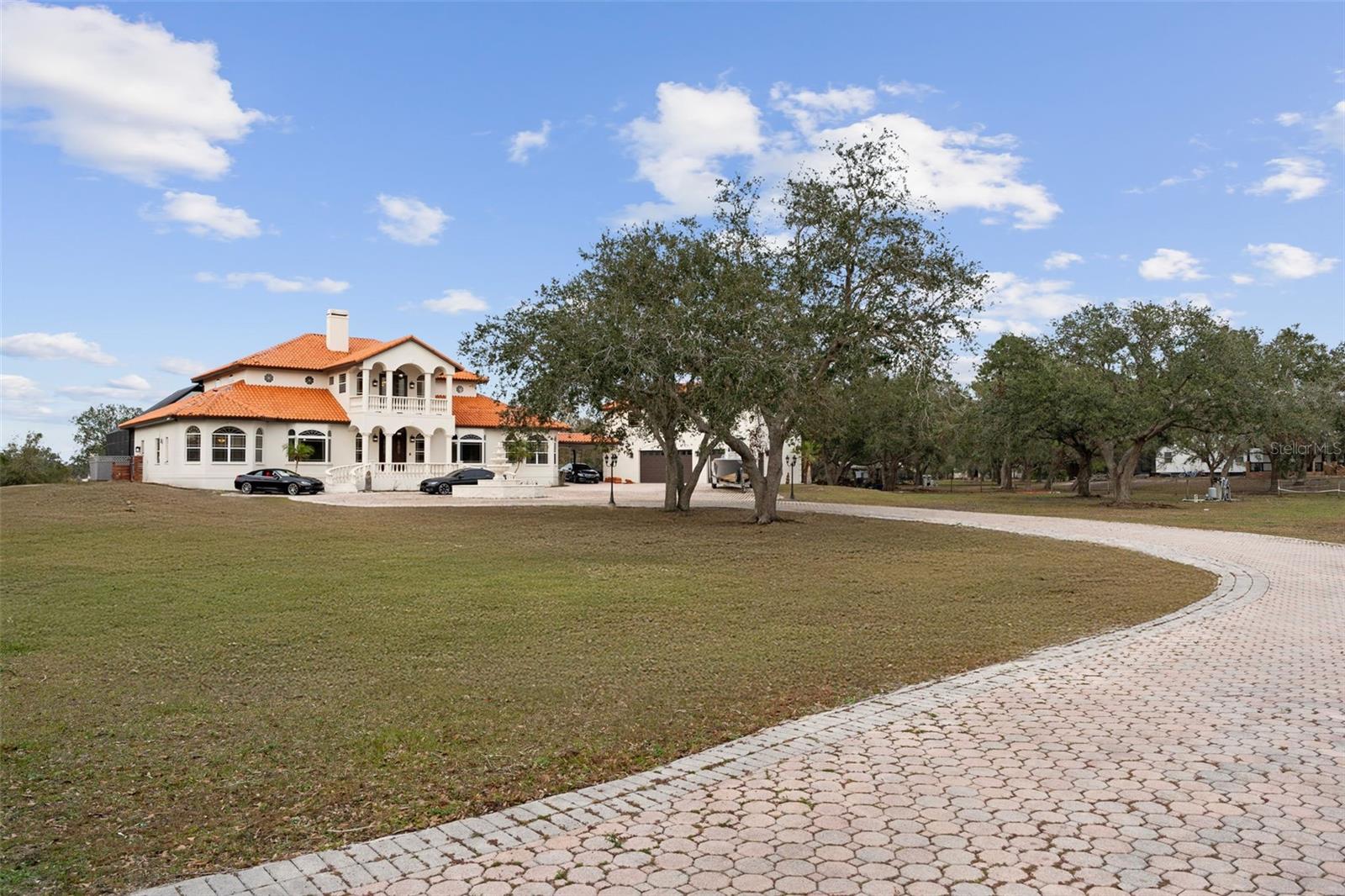 Welcome to your very own 10-acre Mansion!** This luxurious 6,232 sq. ft. estate offers an unparalleled living experience with an array of exceptional features for both comfort and entertainment.
**Key Features:**
- 6 bedrooms, 6 bathrooms, 2 dining rooms, and a private office provide ample space for family and work.
- A large game room offers endless entertainment options.
- The master suite includes a private living room with a wet bar and access to the front balcony for a peaceful retreat.
- **Stunning Outdoor Living:**
- The 3,600 sq. ft. screened-in pool area** features a **9-foot deep saltwater pool** with Versace tile, Italian marble penny tiles, and a diving board. The pool & spa is gas-heated.
- The Hot Tub fits 12 adults, perfect for relaxation.
Enjoy breathtaking views from the 51-foot-long rear balcony, which overlooks the pool, your private lake, and the expansive land.
- A charming front balcony offers views of the grand oak-lined driveway.
- **Additional Living Space:**
The 750 sq. ft. mother-in-law apartment offers its own kitchen, 2 bedrooms, 1 bathroom, and living room, providing privacy and comfort.
- Above the oversized 3-car garage, another 1,000 sq. ft. guest house awaits your personal touch—ideal for a mancave, extra living space, or another apartment.
- **Private & Secure:**
Enter through your own private gate and enjoy the 11,000 sq. ft. pavered driveway, offering ample space for your vehicles, RVs, boats, and more.
- This estate is fully fenced in and includes 2 pasture areas.
- Located in a **Ranch Community** with minimal deed restrictions, it’s pet - horse and livestock-friendly.
- **Versatile Land & Development Potential:**
- The 10-acre property allows for two additional structures, whether a detached mother-in-law suite, horse barn, or extra garage—your possibilities are endless!
This estate combines the perfect blend of luxury, privacy, and versatility. **Don’t miss the opportunity to own this extraordinary property —schedule your private showing today and start imagining the life you’ve always dreamed of!