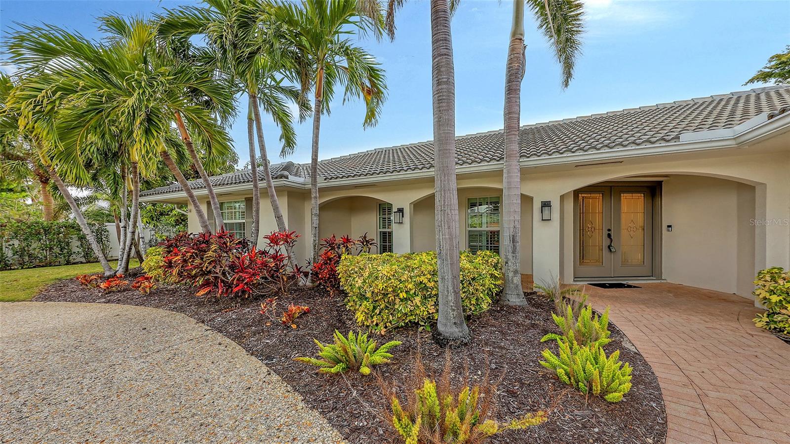 This lovely Bird Key garden home resides on a corner lot with a large circular paver driveway and beautiful landscaping that leads to the front door with the 2 car garage located on the side of the house. Inside, you will find abundant natural light with many windows and glass sliders that afford a splendid view of the large yard and pool area with a private garden wall. This three-bedroom residence has a split floor plan offering a private master suite, complete with 2 walk-in closets, an en-suite bathroom, and sliding doors to the pool deck. The two guest bedrooms and a second bathroom complete the other end of the house. A powder room and an oversized laundry room with a sink and loads of storage are a bonus not found in many garden homes. The kitchen overlooks the large backyard and pool area, with granite countertops, stainless steel appliances, and a breakfast bar overlooking the family/dining room. The house has high-impact windows & sliding doors, a heated pool, a well for irrigation, and mature lush landscaping that provide privacy and a large fenced back yard. The most recent upgrades and improvements from the interior to the exterior include re-ling the plumbing under the slab. The garage was gutted, painted and the floor epoxied. Updated interior baseboards and stunning interior lighting were installed throughout the home, giving it an updated, sleek look. This home is move-in ready. Live the comfortable Florida dream by opening large sliders to the pool area, with neutral tile throughout and a spacious flowing floorplan that makes the indoor-outdoor lifestyle easy. This residential island has its own optional Bird Key Yacht Club, tennis courts, swimming pool, fitness room, social scene, boat slips, marina, indoor and outdoor dining. These are the perfect ingredients for making this your private island retreat, complete with nearby beaches, dining, shopping, excellent schools, and the beautiful downtown area.