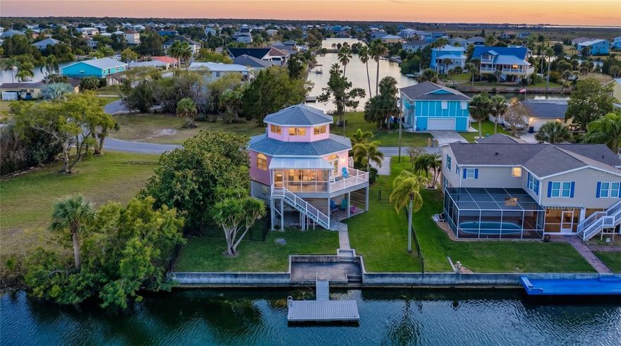 ICONIC PINK three-story octagon WATERFRONT home with PRESERVE & GULF VIEWS – ACTIVE VACATION RENTAL – SOLD TURNKEY in Hernando Beach!
Welcome to one of the most unique and eye-catching homes on the coast—this 3-story octagon WATERFRONT retreat perfectly positioned to capture BREATHTAKING PRESERVE AND GULF VIEWS. Located in the heart of Hernando Beach, this TURNKEY property blends architectural character, modern updates, and the ultimate FLORIDA COASTAL lifestyle.
The second-story MAIN LIVING LEVEL features an OPEN-CONCEPT floor plan filled with natural light, SHIPLAP accent walls, and seamless INDOOR-OUTDOOR living. The DESIGNER KITCHEN showcases GRAY SHAKER CABINETRY, QUARTZ COUNTERTOPS, TILE BACKSPLASH, FLOATING SHELVES, FARMHOUSE SINK, GLASS-TOP COOKTOP, BUILT-IN OVEN, AND HOOD VENT. This level also offers a spacious guest bedroom, full bath with GLASS-ENCLOSED tub/shower combo, and a convenient laundry area tucked behind a stylish BARN DOOR. Step outside to enjoy COASTAL BREEZES from both the BALCONY AND SCREENED PORCH overlooking the peaceful PRESERVE.
A striking SPIRAL STAIRCASE leads to the third-level PRIMARY SUITE, where you’ll find the most spectacular PANORAMIC VIEWS in the home. Take in SWEEPING SUNSETS, GULF WATERS, AND UNTOUCHED NATURAL LANDSCAPES from your private retreat. The suite features a WALK-IN CLOSET with custom shelving and a beautifully updated ENSUITE BATHROOM with CUSTOM VANITY AND WALK-IN SHOWER WITH GLASS ENCLOSURE AND NICHE.
The outdoor space is designed for true COASTAL LIVING with 75 FEET OF WATERFRONT, a CONCRETE PATIO, and a FLOATING DOCK. Launch your KAYAK OR PADDLEBOARD directly from your backyard and explore serene MANGROVE-LINED WATERWAYS. The FULLY FENCED YARD with two separate sections provides flexibility for PETS, ENTERTAINING, OR FUTURE POOL ADDITION.
Additional highlights include a 2021 ROOF, contributing to approximately $2,501/YEAR HOMEOWNERS INSURANCE, and approximately $4,370/YEAR FLOOD INSURANCE.
Located just a short distance to the HERNANDO BEACH BOAT LIFT, offering EASY ACCESS TO THE GULF for boating enthusiasts.
Currently operating as an ACTIVE SHORT-TERM VACATION RENTAL and being SOLD FULLY FURNISHED / TURNKEY, this property is ideal as a PRIMARY RESIDENCE, SECOND HOME, OR INCOME-PRODUCING INVESTMENT.

Located in the vibrant HERNANDO BEACH WATERFRONT COMMUNITY, residents enjoy BOATING, KAYAKING, PADDLEBOARDING, FISHING, AND DIRECT ACCESS TO THE GULF. Just minutes from Weeki Wachee Springs State Park, plus nearby SHOPPING, DINING, AND MEDICAL FACILITIES. The area is GOLF CART FRIENDLY, allows SHORT-TERM RENTALS, and has NO HOA AND NO DEED RESTRICTIONS, making it ideal for FULL-TIME LIVING, A VACATION HOME, OR A HIGH-PERFORMING INVESTMENT PROPERTY. With convenient access to the Suncoast Parkway, commuting to Tampa, Brooksville, and surrounding areas is easy. RARE, ICONIC, AND UNLIKE ANYTHING ELSE ON THE MARKET -- YOUR WATERFRONT PARADISE AWAITS.