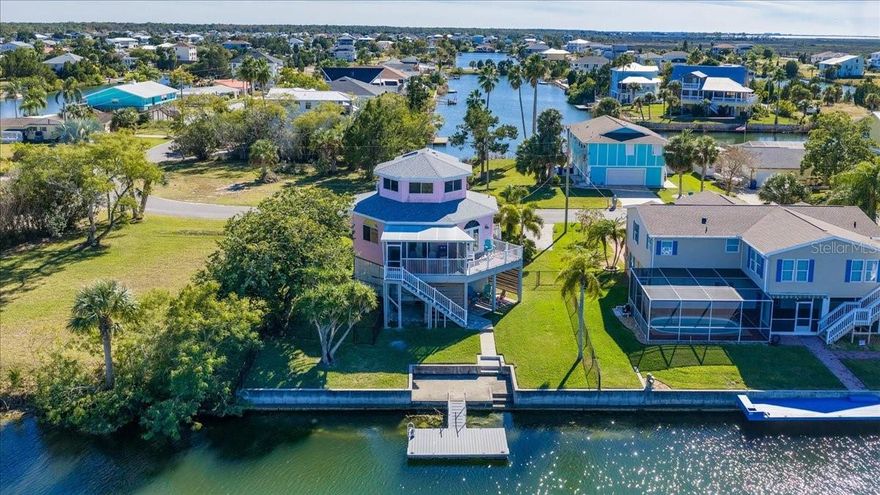 ICONIC PINK THREE-STORY OCTAGON WATERFRONT HOME with PRESERVE & GULF VIEWS - TURNKEY! Welcome to this stunning 3-STORY OCTAGON COASTAL RETREAT perfectly positioned to capture BREATHTAKING PRESERVE AND GULF VISTAS in the heart of HERNANDO BEACH. This unique TURNKEY WATERFRONT HOME blends character, craftsmanship, and coastal charm across three thoughtfully designed levels. The SECOND STORY - THE MAIN LIVING LEVEL - features an OPEN-CONCEPT FLOOR PLAN filled with natural light, SHIPLAP ACCENT WALLS, and seamless indoor-outdoor living. The DESIGNER KITCHEN showcases GRAY SHAKER CABINETRY, QUARTZ COUNTERTOPS, TILE BACKSPLASH, FLOATING SHELVES, FARMHOUSE SINK, GLASS-TOP COOKTOP, BUILT-IN OVEN, AND HOOD VENT. This level also includes a SPACIOUS GUEST BEDROOM, FULL BATH WITH TUB/SHOWER COMBO AND GLASS ENCLOSURE, and CONVENIENT LAUNDRY tucked behind a stylish BARN DOOR. Step outside to enjoy COASTAL BREEZES from both the BALCONY AND SCREENED PORCH overlooking the serene PRESERVE. A charming SPIRAL STAIRCASE leads to the THIRD-LEVEL PRIMARY SUITE, offering the MOST SPECTACULAR PANORAMIC VIEWS in the home. From this elevated vantage point, enjoy SWEEPING SUNSETS, GULF WATERS, AND UNTOUCHED PRESERVE LANDSCAPES. The private suite features a WALK-IN CLOSET WITH CUSTOM SHELVING and a BEAUTIFULLY UPDATED ENSUITE BATHROOM with CUSTOM VANITY AND WALK-IN SHOWER WITH GLASS DOOR AND NICHE. Outside, the property truly shines with 75 FEET OF WATERFRONT, a CONCRETE PATIO, and a FLOATING DOCK perfect for embracing the FLORIDA COASTAL LIFESTYLE. Launch your KAYAK OR PADDLEBOARD RIGHT FROM YOUR BACKYARD and explore peaceful MANGROVE-LINED WATERWAYS through the nearby preserve. The FULLY FENCED YARD WITH TWO SEPARATE SECTIONS offers flexibility for PETS, GARDENING, OR ENTERTAINING. Additional highlights include a 2021 ROOF, helping contribute to a LOW APPROX. 2,501 dollars a YEAR HOMEOWNERS INSURANCE COST, and a location NEAR THE HERNANDO BEACH BOAT LIFT for easy boating access. Home is currently being used as a ACTIVE SHORT TERM VACATION RENTAL and is being SOLD FULLY FURNISHED / TURNKEY, making this property ready for immediate enjoyment or rental potential. Located in the vibrant HERNANDO BEACH WATERFRONT COMMUNITY, residents enjoy BOATING, KAYAKING, PADDLEBOARDING, FISHING, AND DIRECT ACCESS TO THE GULF. Just minutes from Weeki Wachee Springs State Park, plus nearby SHOPPING, DINING, AND MEDICAL FACILITIES. The area is GOLF CART FRIENDLY, allows SHORT-TERM RENTALS, and has NO HOA AND NO DEED RESTRICTIONS, making it ideal for FULL-TIME LIVING, A VACATION HOME, OR A HIGH-PERFORMING INVESTMENT PROPERTY. With convenient access to the Suncoast Parkway, commuting to Tampa, Brooksville, and surrounding areas is easy. RARE, ICONIC, AND UNLIKE ANYTHING ELSE ON THE MARKET -- YOUR WATERFRONT PARADISE AWAITS.