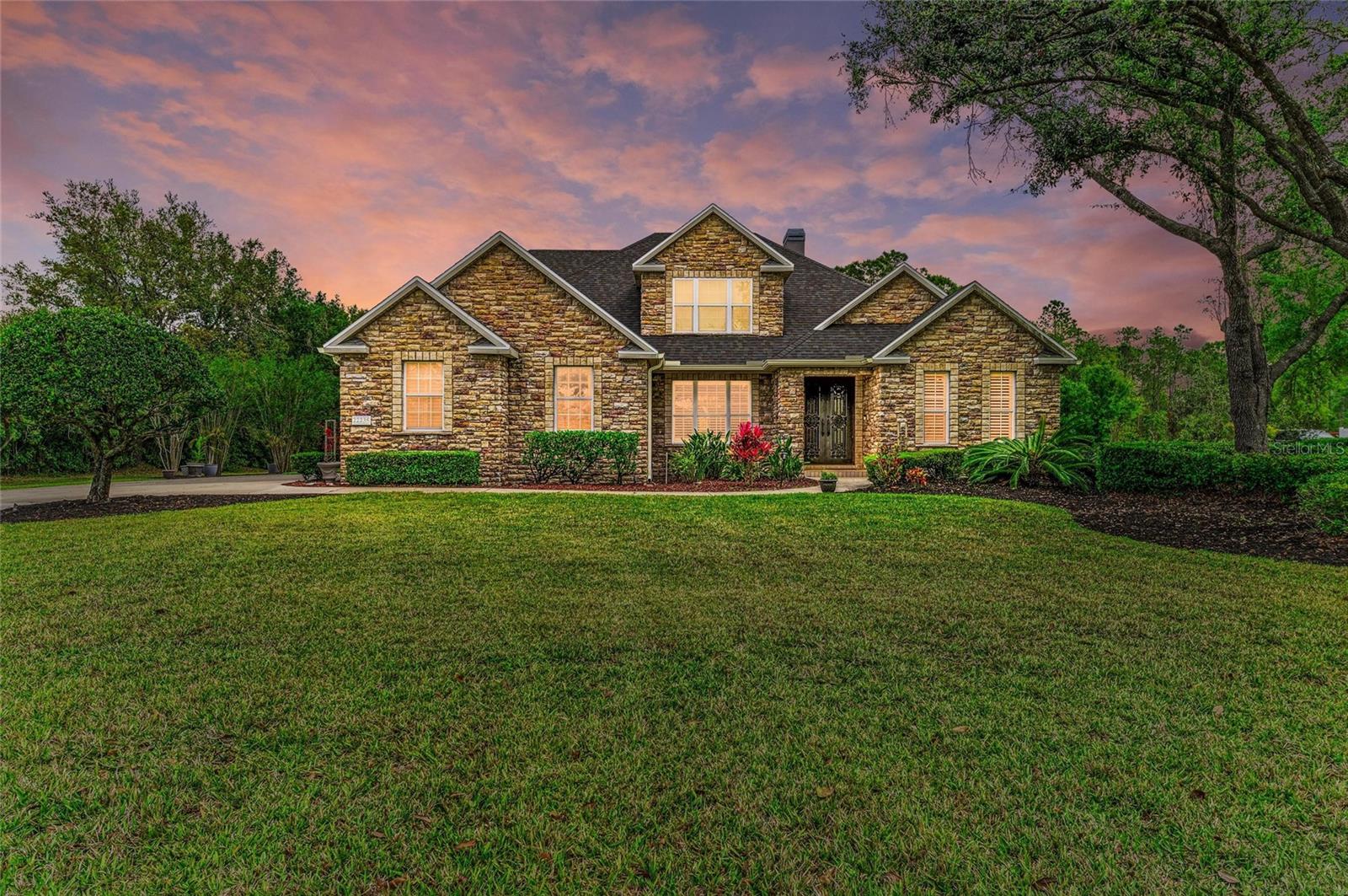 "MOTIVATED SELLERS, MOVING OUT OF STATE WITH CONTINGENT ON ANOTHER PROPERTY".
This stunning Cahill custom model home is a rare gem in The Preserve at Panther Ridge. Nestled on one of the most private lots in the community, this 4-bedroom, 3-bathroom home—with a dedicated office—boasts exceptional craftsmanship and breathtaking design.
From the moment you arrive, the home's striking exterior, adorned with beautiful stonework, sets it apart. Step through grand double wrought-iron doors into a space of warmth and elegance, where a two-story rock fireplace creates a dramatic yet inviting focal point.
The private office, complete with double doors and large, bright windows, offers a perfect workspace. The open dining area is ideal for entertaining, seamlessly flowing into the newly remodeled kitchen. Here, granite countertops, a spacious island, and brand-new appliances make this a chef’s dream. The breakfast nook overlooks the sparkling pool and lush backyard, creating a serene dining experience.
The primary suite is a true retreat, offering peaceful pool and backyard views, a generous walk-in closet, and an en-suite bath featuring a garden tub, dual sinks, and a walk-in shower. The first floor also includes a second bedroom and a full bath for convenience.
Ascend the beautiful staircase to a catwalk with a stunning overlook of the family room and fireplace. The second floor features two additional bedrooms and a spacious Jack-and-Jill bathroom, providing privacy and comfort.
Step outside to your own private oasis. The expansive pool area is enclosed with a panoramic screen, offering unobstructed views of the lush landscape. As night falls, the ambient cage lighting creates a magical star-like effect. The backyard is a peaceful haven, surrounded by mature trees and open space—ideal for relaxation or outdoor gatherings.
The Preserve at Panther Ridge offers a vibrant lifestyle with scenic walking trails, parks, a playground, basketball courts, and tennis courts. Conveniently located near Waterside, Lakewood Ranch Main Street, and UTC Mall, you'll enjoy easy access to top-tier shopping, dining, and entertainment.
Additional Highlights:
• No CDD
• Low HOA
• New roof 2020
• Hurricane rated windows upstairs, front door, pool screen.
All offers welcome.