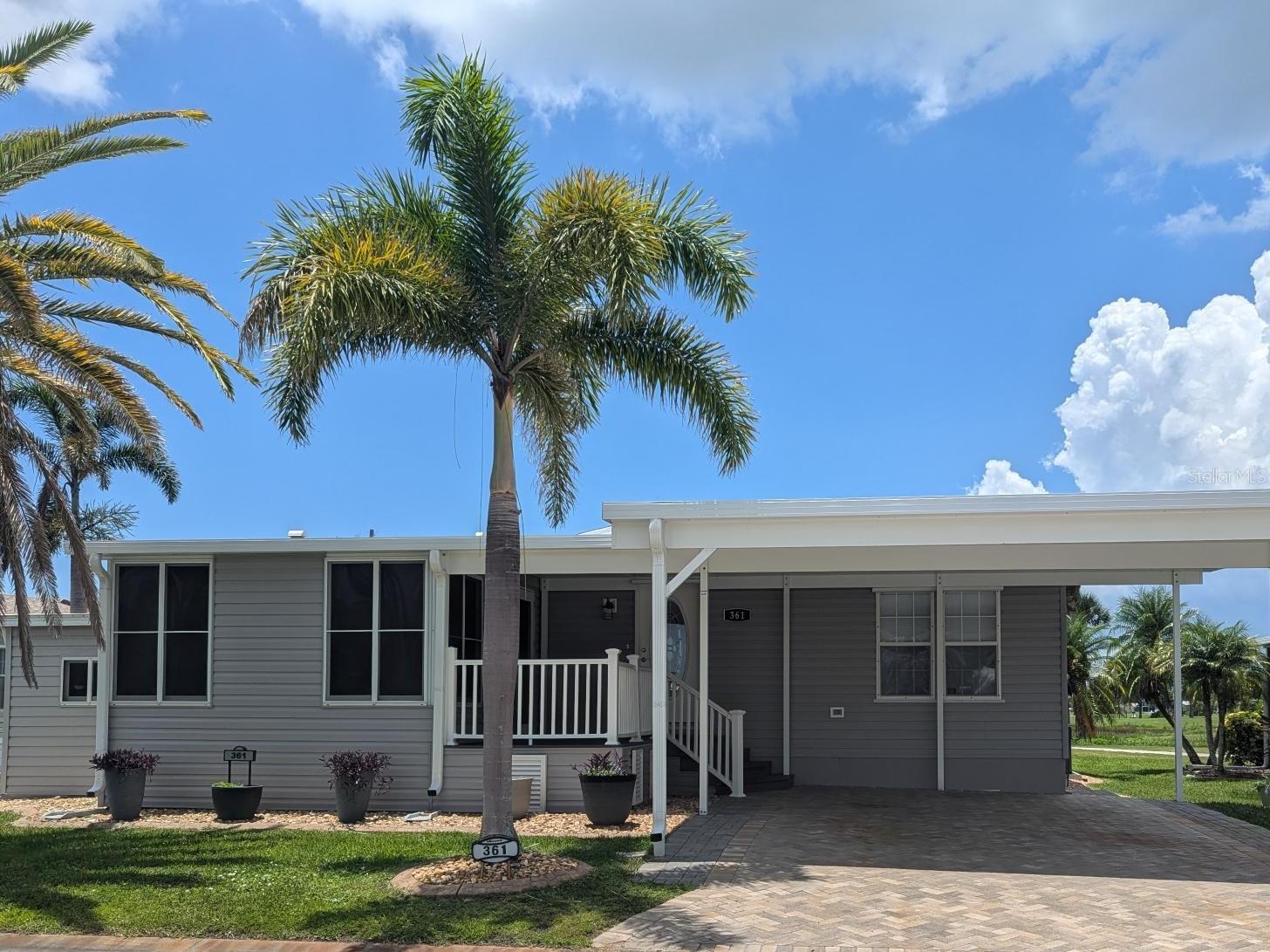 Looking for a remodeled custom home on the Golf Course with FANTASTIC SUNSET VIEWS from your back deck. This 2006 Jacobsen 2 Bedroom/2 Bath split floor plan located at #361 Queensway between the 3rd green and 4th tee is the one you must see. New flooring in bedrooms and TOTAL REMODEL in the Primary bathroom in 2020 which includes a walk-in rain shower, custom double sink cabinets w/soft close doors and drawers and Quartz countertops. Not to be outdone but added more storage with a new linen pantry/closet.
The sellers also did a TOTAL KITCHEN REMODEL in 2020, GE Dark Stainless Appliances, Recessed lighting, New Wood Cabinets with pantry that has pull out shelving and soft close drawers/cabinets featuring cabinet underlighting! The Quartz Countertops are a fantastic addition to all the upgrades including the new vinyl flooring. The sellers have added so many touches which include Valances to add that special custom touch!
The Sellers didn’t stop remodeling and in 2022 they Extended the carport providing an OVERSIZED upgraded wide paver stone driveway. The sellers remodeled and insulated the lanai and added a split air conditioning unit adding more living space. To top it off the sellers replaced the NEW SHINGLED ROOF IN 2022 (permitted)! The Exterior features, BRAND NEW SIDING in 2020 along with NEW WINDOWS on the full backside of the home with an oversized picture window and in Bedroom. The sellers added an extended front porch in 2021 (permitted), NEW VINYL ROOF on the porch and shed in 2021 (permitted). This home has hurricane shutters for extra storm protection. Why spend months living in a construction zone, making countless decisions, and coordinating with contractors, instead this home is completely done for you, freeing up time for more enjoyable activities like making tee times and getting together with friends. Come LIVE YOUR BEST LIFE in this Florida Resort community a Fantastic 55+ Resident-Owned Amenity-Rich Guard Gated Community has a fantastic 18 Hole Par 62 Executive Golf Couse, offering Five Tennis Courts, Four Pickleball Courts, Fitness Room, Heated Swimming Pools, Clubhouses, Fishing Lakes, Bocce Ball, Lawn Bowling, Shuffle Board Courts, Mini-Putt, Horseshoes, Over 75 Special Clubs, Arts & Crafts, Cards, Bingo, Woodworking Shop, Ceramics and Computer Club. Enjoy the On-Site Restaurant/Full-Service Bar for Dinners, Music & Entertainment, and a Tiki Bar over the Water perfect for sunsets and enjoying time with friends!