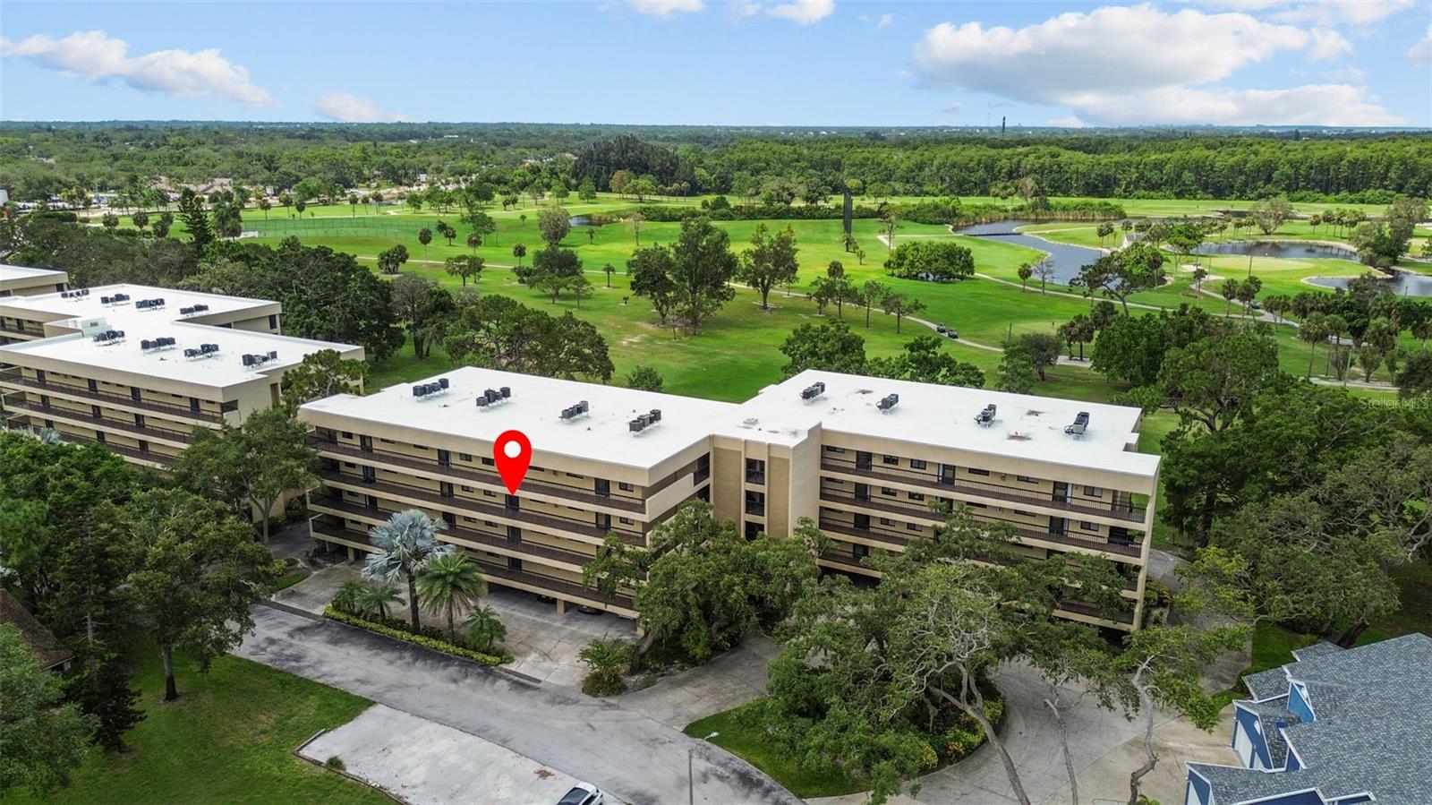 Discover carefree living in the vibrant 55+ community of Green Dolphin with this beautifully maintained 2-bedroom, 2-bath condo, perfectly positioned on the third floor to take full advantage of breathtaking golf course views. As you enter, a charming foyer welcomes you into a bright, open-concept layout, where natural light pours through the large windows and sliding glass doors. The kitchen, tucked to the right, features a cozy breakfast nook and breakfast bar, while the adjacent living and dining areas showcase newly installed luxury vinyl plank flooring for a fresh, modern touch. Step outside to your spacious screened lanai, accessible from both the living and dining rooms, where you'll enjoy sweeping views of the lush golf course—an ideal backdrop for morning coffee or evening unwinding. The split bedroom floorplan provides privacy and functionality, with the guest bedroom conveniently located near the second bathroom, which features a walk-in shower. A dedicated laundry closet with full-size washer and dryer adds convenience to everyday living. The owner’s suite is a peaceful retreat with its own set of sliding doors to the lanai, a large walk-in closet, linen closet, and an en suite bathroom with a dual-sink vanity and a tub/shower combination. Green Dolphin is packed with amenities designed to complement an active lifestyle, including a clubhouse, fitness center, library, billiards room, BBQ grills, tennis and pickleball courts, shuffleboard, and a newly updated pool area. Monthly HOA fees cover premier cable, high-speed internet, water, trash, exterior building maintenance, elevators, and access to all recreational facilities. Enjoy under-building parking with extra storage, plenty of guest parking, and a location that can’t be beat—just moments from the historic Tarpon Springs Sponge Docks, charming downtown shops and restaurants, medical facilities, golf, the Pinellas Trail, and nearby beaches. Come experience the lifestyle you’ve been waiting for—this is more than a condo, it’s a gateway to everyday enjoyment.