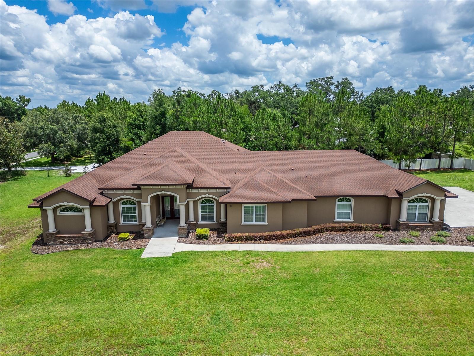 CUSTOM-BUILT 2021 HOME ON OVER 1 ACRE + 4-CAR GARAGE + SMART HOME UPGRADES THROUGHOUT!
This show-stopping 4 BEDROOM, 4 BATHROOM home delivers nearly 4,700 square feet of CUSTOM DESIGNED and BUILT living space with NO DETAIL OVERLOOKED. Sitting on a sprawling, manicured lot with a 15-FOOT COVERED FRONT ENTRY and tons of privacy, this property offers the perfect blend of upscale living, space, seclusion & impressive finishes!
As you step inside you’ll ABSOLUTELY LOVE the SOARING 10- and 12-FOOT CEILINGS, TRAVERTINE AND MARBLE FLOORING throughout, and 8-FOOT DOORS and SLIDING GLASS DOORS for that high-end feel. The FAMILY ROOM features RECESSED CEILINGS, SURROUND SOUND, and a wide-open flow - straight to the heart of the home — the CHEF’S KITCHEN. This space is fully loaded with GRANITE COUNTERS, TONS OF CABINET SPACE, a WINE COOLER tucked under the CENTER ISLAND, BUILT-IN SAMSUNG STAINLESS STEEL APPLIANCES, TOUCHLESS FAUCET, POT FILLER, and an OSMOSIS WATER SYSTEM under the sink.
Hosting and Entertaining is what this house is designed for and it is a breeze with the oversized 563-SQUARE-FOOT COVERED LANAI featuring an OUTDOOR KITCHEN, AUTOMATIC TV MOUNT, and SURROUND SOUND. Whether it’s movie night or game day, the dedicated THEATER ROOM brings the action to life with RECESSED CEILINGS and built-in sound. Need extra space? The BONUS ROOM offers flexibility for an office, game room, gym — whatever suits your lifestyle.
The MASTER BEDROOM is a true owner's space with a separate SITTING AREA, large WALK-IN CLOSET with CUSTOM BUILT-INS, and a master bathroom featuring a WRAP-AROUND SHOWER, DUAL VANITIES, JACUZZI TUB, and RECESSED CEILINGS. The other bedrooms are oversized and designed for function and comfort.
This home is packed with modern SMART HOME FEATURES, including control of lights, ceiling fans, AC, WATER SOFTENER, water heater, refrigerator, oven, SPRINKLER SYSTEM, garage doors, and SURROUND SOUND — all at your fingertips. There's also a POWER BACKUP PORT for a generator to keep you running during storms.
Outside, you'll find a 1,200-SQUARE-FOOT GARAGE, 2 HORSEPOWER WELL PUMP, 2-TANK GRAVITY-FED SEPTIC SYSTEM, professional landscaping with OUTDOOR PLANTERS, and even SURVEILLANCE CAMERAS viewable from every room. The home is wired with a LAN NETWORK and an attic-mounted LOCAL ANTENNA for TV stations.
Located just MINUTES to I-4 and I-75, this property offers QUICK ACCESS to Downtown TAMPA, ORLANDO, PLANT CITY, major commuter routes, and all the dining, shopping, malls and entertainment the area has to offer. It is about an hour to Disney, Universal, and the World Famous Beaches of Clearwater! Tampa International Airport is about a 30 minute drive. — all while enjoying the peace and space of your private Dover/Plant City Estate. You can have it all!