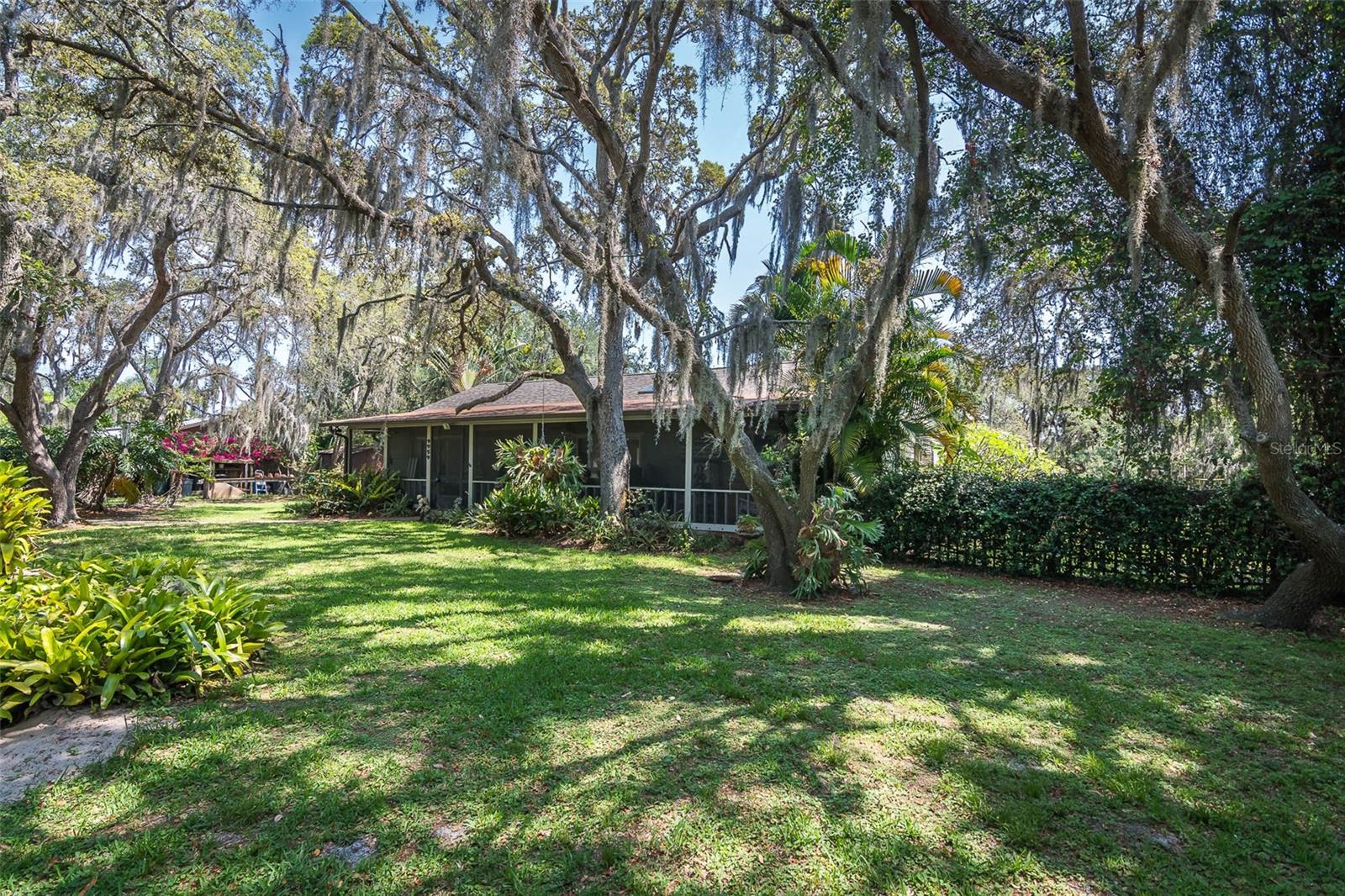 Full of character and timeless appeal, this home features a 2023 roof and sits on a spacious 0.82-acre lot with mature trees, privacy, and no HOA. A large front porch welcomes you in, while vaulted tongue-and-groove ceilings and a wood-burning fireplace add warmth and style to the open living, dining, and kitchen areas. The kitchen includes a peninsula with bar seating, ideal for entertaining. Tile floors run throughout, with wood in the bedrooms for added comfort. The oversized laundry room offers patio access and extra storage. Step outside to a generous pool deck surrounded by nature. The 576 SF detached garage/workshop provides endless options for hobbies, storage, or creative use. There's ample space to park your RV or boat, and you're just minutes from the Indian River, a public fishing pier, marina, docks, and waterfront restaurants” perfect for boating and coastal living. This original home blends space, charm, and an unbeatable location”a truly special place to call home!