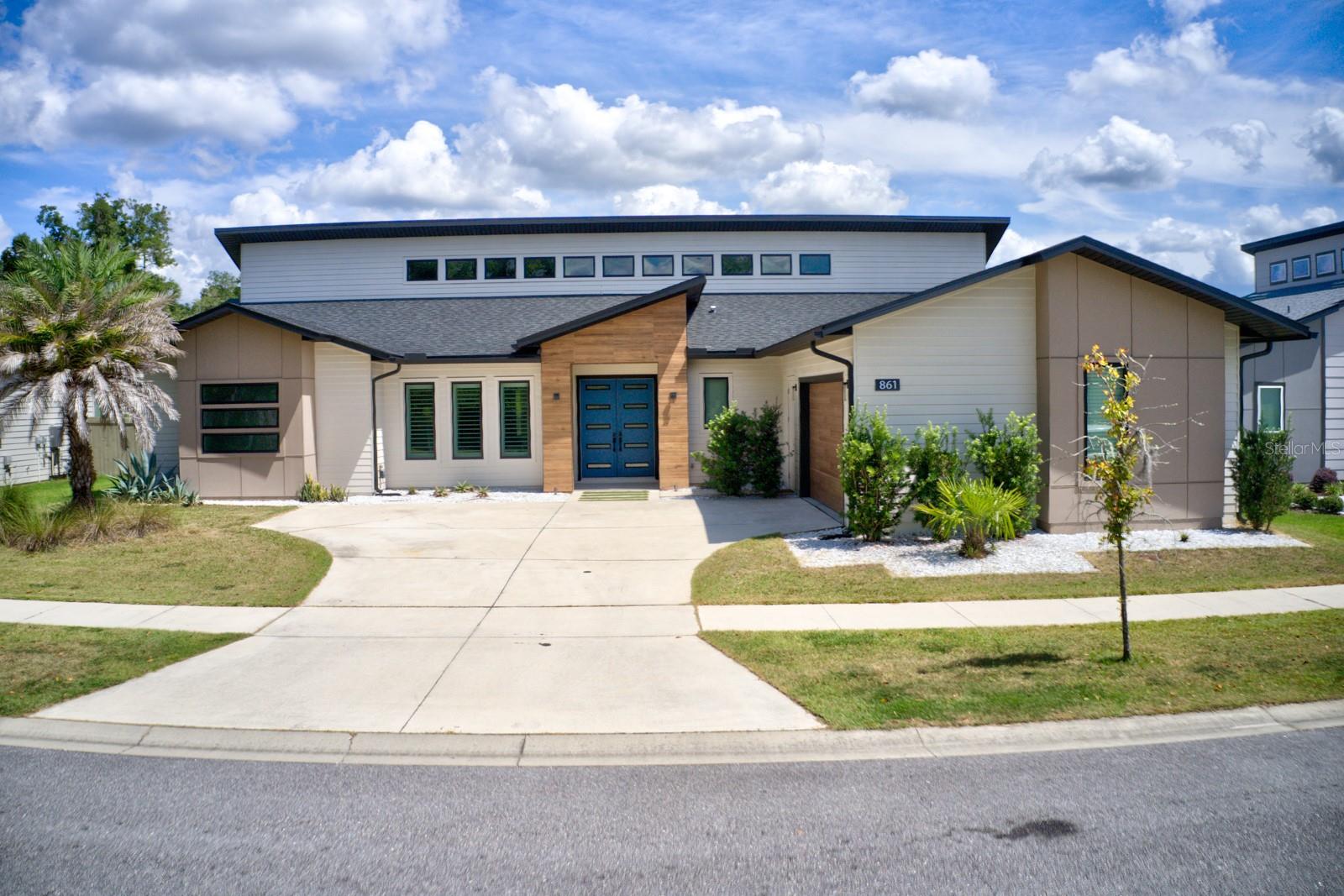 861 SW 120th Drive - Stunning Contemporary 4BR/4BA Home with Bonus Room – Designed with Every Detail in Mind This 3,156 sq. ft. newly constructed residence offers a bright, open-concept layout built on a reinforced post-tension foundation for lasting durability. Thoughtful upgrades include plantation shutters, 8’ interior doors, and expansive windows that flood the home with natural light. Wood-look porcelain tile extends throughout the main living areas and study, complemented by custom designer lighting. The gourmet kitchen showcases sleek European-inspired cabinetry, quartz countertops with a dramatic waterfall island, farmhouse sink, stylish tile backsplash, and premium stainless steel appliances, including a gas cooktop with vented hood, built-in oven/microwave combo, and dishwasher. Striking pendant lights highlight the spacious center island—perfect for gathering and entertaining. The sunlit family room features a soaring vaulted ceiling and oversized sliding glass doors that open to a generous covered lanai, overlooking a beautifully landscaped, fully fenced, and irrigated backyard. The owner’s suite includes dual walk-in closets, a spa-inspired bath with quartz dual vanities, and a custom-tiled walk-in shower. Each of the three guest bedrooms offers its own walk-in closet and en suite bath. Energy-efficient features include Icynene spray foam insulation, low-E insulated vinyl windows, and a tankless water heater. Nestled in the sought-after Glorias Way community, this home is ideally located near Tioga Town Center and just minutes from Celebration Pointe’s shopping, dining, and entertainment.