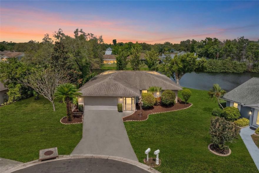 Located on a quiet cul de sac in the established community of University Pines just off University Parkway, this three bedroom, two bath lakefront home is positioned on one of the finest homesites in the neighborhood. Situated on an oversized homesite of approximately two thirds of an acre and set at approximately 30 feet of elevation in an X flood zone, with approximately 120 feet of lake frontage, the property offers expansive lake views, exceptional privacy, and a truly remarkable outdoor setting that would stand out anywhere. The property is equipped with a full irrigation system supplied by reclaimed lake water, providing an efficient and consistent source for maintaining the mature landscaping and expansive grounds. The home lends itself equally well to full time living, seasonal use, or short term rental opportunities, offering flexibility while the neighborhood itself maintains a quiet, residential atmosphere. From the moment you enter, your eye is drawn through the living space to the elevated pool and patio overlooking the lake. Because of the natural elevation, the outdoor area has the feel of an infinity edge setting, with wide long water views, open sky, and mature trees creating a peaceful and dramatic backdrop. As the sun sets, the landscape changes each evening with beautiful reflections across the water and sky, making the backyard feel like a private retreat. Designed for enjoying the Florida lifestyle, the outdoor living space is truly a standout feature of the home, with a heated saltwater pool, spa, expansive deck area, covered seating, and a fully equipped summer kitchen. The natural height of the lot creates a sense of space and privacy rarely found, giving the entire backyard an almost estate like feel, with a level of openness and tranquility that is difficult to replicate while still being close to everything along the University Parkway corridor. Inside, the home has been lovingly maintained by long term owners and has never been used as a rental. Recent updates include a 2019 roof, 2018 air conditioning system, and a 2024 hot water heater. Wood flooring flows throughout the home, and the floor plan offers a welcoming foyer entry, a spacious living room with views of the pool and lake, and a dining area with windows overlooking the outdoor space. The kitchen features solid wood cabinetry, granite countertops, quality appliances, and a breakfast bar that opens to the dining area, creating a comfortable and functional layout. The primary suite is generously sized with an en suite bath, large walk in closet, and sliding doors leading directly to the pool area. The second bedroom is well proportioned, and the third bedroom is currently used as an office but easily serves as a full third bedroom.
University Pines is a small, well established neighborhood of fewer than 80 homes with mature landscaping and long term residents, located just moments from University Parkway, UTC, I-75, shopping, dining, and the Sarasota Bradenton airport. The home carries a Sarasota address but is located in Manatee County, providing additional rental flexibility while preserving the peaceful residential feel of the community. Rental projections are available upon request for buyers interested in seasonal or short term use. Property video, 3D walk through tour, floor plan, and updated four point and wind mitigation report are also available. Call today for a private showing.
