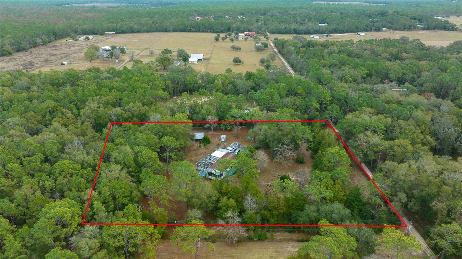 BROOKSVILLE FLORIDA RETREAT ON 2.4 ACRES — POOL + BARN + MOTHER-IN-LAW SUITE! Dreaming of wide-open space, fresh country air + room for all your hobbies? Welcome to this 4-BEDROOM, 3-BATHROOM HOME in beautiful BROOKSVILLE, FL — complete with an IN-LAW SUITE, SCREEN-ENCLOSED POOL, and a BARN, all on 2.4 ACRES ZONED AGRICULTURAL! From the moment you arrive, you'll love the feeling of privacy. An ELECTRIC GATE welcomes you onto the property, leading down a long driveway to your secluded retreat. The MAIN HOME offers over 1,600 SF OF LIVING SPACE with WOOD FLOORING, a cozy FRONT PORCH, and even an OFFICE/DEN that's perfect for work or extra living flexibility. Need space for extended family or guests? The attached MOTHER-IN-LAW SUITE has its own PRIVATE ENTRANCE, FULL KITCHEN, bathroom, and SCREENED PORCH — giving everyone their own slice of comfort. And when it's time to unwind? Head outside to the SCREEN-ENCLOSED IN-GROUND POOL, perfect for cooling off on hot Florida afternoons or hosting weekend gatherings. The property also features a BARN/STABLE, ideal for animals, projects, or storage, plus a STORAGE SHED and multiple porches where you can relax and take in the peaceful surroundings. With AGRICULTURAL ZONING, the possibilities are endless — bring your horses, start a garden, or create the homestead you've always dreamed about. All of this in the heart of BROOKSVILLE, a charming Florida town known for its rolling hills, local farms, historic downtown, and easy access to Tampa, Orlando, and the Gulf beaches. Homes with this much SPACE + POTENTIAL + LIFESTYLE don't come around often — don't miss your chance to make this one yours! NO HOA, NO FLOOD ZONE!!!
