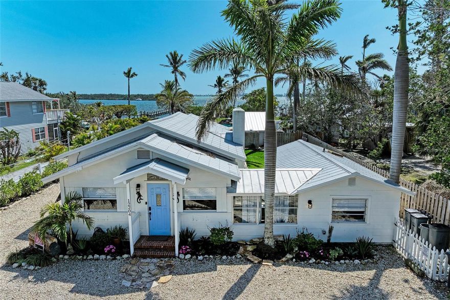 Welcome to Crooked Coconut!  A VERY rarely for sale amazing historic home on Sarasota Bay in the oldest fishing village in the state of Florida, Cortez Village.  One of the original homes in the village!  The interior of this super cool historic home is newly decorated and put together with love and fresh feel you will love. Crooked Coconut is a 3 bedroom 2 bath home that sits on a huge bay front lot.  Tucked back on a dead end street in the village that gives you the privacy you are looking for when you live or just vacation in Florida.  Walk into the home and you are immediately taken over with the feel of coziness and character.  the Foyer is equipped with a sitting area for morning coffee and a good book as well as an area for work if you need.  Get the days emails done at a desk with lots of room.  The large living room has a fireplace and room for everyone to enjoy the game or a good movie for family time.  The newly done floors are a light tan herringbone and gives the home a beautiful feel throughout.  With a split bedroom design, the Primary bedroom is on the West side of the home as you walk through the hall way giving you tons of privacy.  A built in closet with built in shelves is perfect for your summer wardrobe collection.  Continue on to the primary bathroom with a black and white penny tile and walk in shower.  Just off this bathroom you will find the laundry room with brand new stackable washer and dryer and a large closet for storage or turn it into a wine cellar!  The other two bedrooms are just off the large living room and have a jack and Jill bathroom for them both.  The beautifully done kitchen has just the right touch of modern and cottage feel to it with one of the original walls of the cottage exposed and redone.  All the appliances are new stainless GE profile.  There is a seating area for snacks and chatting while cooking and a large brand new table for 8.  With windows throughout the home, the natural light brings in warmth and excellent lighting.  Just off the kitchen is a large covered porch with comfy Windward furniture for hanging out for happy hour or just getting out of the sunshine for a bit.  From the back porch you will be engulfed by the massive resort style pool and hotter that was just installed a year ago.  There is seating in every corner of the pool and a large sand stone waterfall feature.  Soak up the sun on the sun ledge of the pool or escape to the outdoor bar area for chilling and grilling.  With an outdoor comfort station just off the bar and shed, you'll be able to literally live outside.  Head out to dinner at any of the local fresh fish joints right next door and don't forget to bring a fishing pole to hang out on your newly redone dock.  The guests who have stayed come back over and over!  You just won't be able to not fall in love with Crooked Coconut.  It's a generational home full of history and stories waiting for you to love.