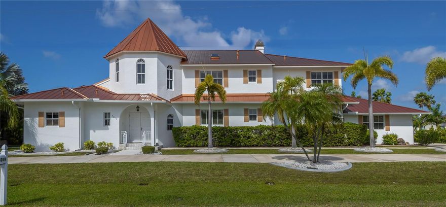 This stunning Mediterranean-style executive estate sits on two premium waterfront lots offering 160 feet of sailboat-access canal frontage — the ultimate setting for the serious boater or coastal lifestyle enthusiast. Located in the sought-after Punta Gorda Isles community, this one-of-a-kind home delivers the perfect blend of Old World elegance and modern Florida waterfront living. Enter through an impressive tower entrance that sets the tone for everything that follows. A beautifully crafted solid oak staircase greets you upon arrival. The heart of the home is a soaring great room with its dramatic ceiling height, walls of windows flooding the space with natural light, and rich oak paneling adding warmth and sophistication. The main sitting area anchors around a classic fireplace — ideal for Florida's cooler evenings — while the open layout accommodates multiple conversation areas perfect for entertaining on any scale. Gleaming 24-inch tile flows throughout the living areas on the main floor, and a wraparound second-floor balcony overlooks the entire space from above. The well-appointed kitchen features 42-inch cabinetry, Corian countertops, stainless steel double refrigerator/freezer, a center island with cook top, built-in desk, and casual dining area. Every inch has been designed for the home chef who loves to entertain. The adjacent formal dining room is bathed in natural light, framed by handsome wood beam ceilings, and overlooks the pool and waterfront. Built-in corner cabinetry throughout provides generous storage without sacrificing style. The expansive master suite is a private sanctuary. A newly installed private elevator connects the master level directly to the upstairs den, adding a sophisticated convenience rarely found in residential properties. The recently updated master bath showcases white wood cabinetry, dual sinks, a deep soaking tub, and a generous walk-in shower. A large walk-in closet and a separate walk-in linen closet ensure that storage is never a concern. An adjoining air-conditioned flex room — ideal as a home gym, workshop, or creative studio — includes a half bath. A second bedroom on the main floor near the entry features a custom built-in bed and walk-in closet, served by a beautifully updated bath with wood cabinetry, marble countertops, and a walk-in shower. Upstairs, a third bedroom offers access to a large cedar-lined closet as well as  a full bath featuring a tub, tile floors, and quartz countertops. At the end of the upper hallway, a handsome oak-paneled den with fireplace provides a quiet retreat. Rounding out the upper level is a delightful English-style pub complete with built-in bar seating and custom woodwork — great for entertaining and a truly unique feature that sets this property apart from anything else in the area. The screened lanai features a sparkling pool and spa alongside a gallery-style covered passage along the exterior of the great room — an elegant transition between indoors and the waterfront. The double-lot configuration and generous seawall provide ample space to dock the boat of your choice with direct sailboat access to Charlotte Harbor and the Gulf of Mexico beyond. Whether you're a day sailor, offshore angler, or simply love waking up to waterfront views, this property delivers the quintessential Florida boating lifestyle. See this property today! You won't be disappointed!