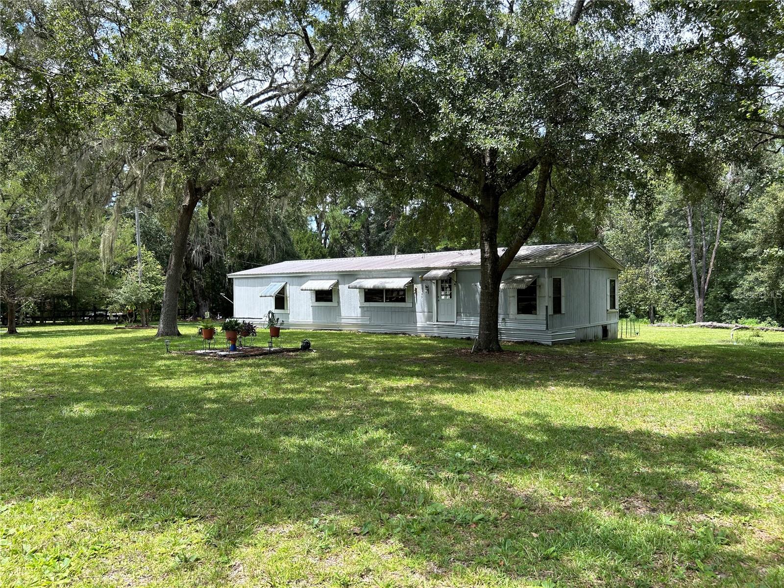 All about location! This beautiful park like 5 acre property resides in the NW amongst beautiful horse farms. 5 acre tracts are a rare find!! especially with the location of being 2.4 miles from Post Time Farm (HIT'S) and 11 miles to the World Equestrian Center. As you pull in on the asphalt driveway, the home will be on the right which is a three bedroom two bath split plan. The kitchen is very workable. Off of the kitchen is a dining room which would be enjoyable for holiday gatherings. The master suite is off to the right. To the left of the dining area is an oversize family room with a woodburning fireplace a perfect place to enjoy with friends and family. The two other bedrooms and bathroom are beyond the family room. very nice split plan and plenty of privacy. As you go out the back door down the ramp into a covered carport/lanai great place to gather on those cooler days here in Ocala Florida. Easy access to the pole barn/workshop with a cement sidewalk that leads you to the back door of the pole barn/workshop a nice little niche to store, tools or crafts, which then would lead you into the oversize workshop plenty of room to park an RV/cars. If you like to work on vehicles there is a car left. 2 acres are cleared 3 acres are wooded with a little bit of clearing there is plenty of space for expansion to add a barn, paddocks, or even more. this property really does provide the flexibility to meet all the needs of all the Equestrians who want to be close to the AMAZING Horse amenities or for those looking for privacy and space and to enjoy nature at its best. this is a unique and one of a kind find. This is a must see!!