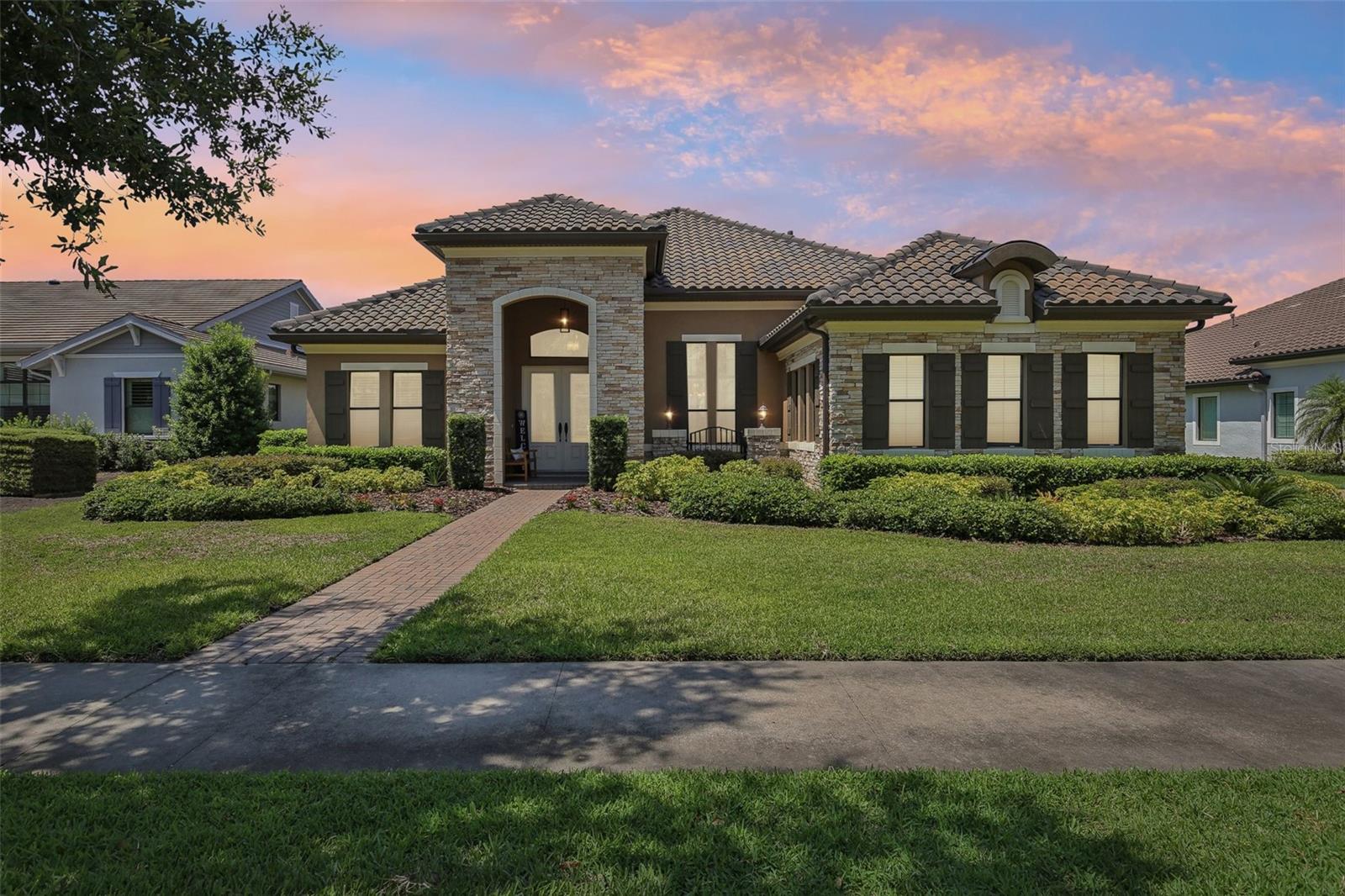 Welcome to 14715 FishHawk Preserve Drive—a beautifully upgraded WestBay “Carrera” executive home in the exclusive gated enclave of The Preserve at FishHawk Ranch. This spacious one-story residence offers over 3,600 sq ft of functional luxury on a private, elevated lot. You’ll be immediately impressed by the tile roof, stacked stone accents, pavered driveway, and side-entry garage. Inside, the home boasts soaring ceilings, wide baseboards, crown molding, and neutral tones, creating an elegant and welcoming atmosphere. A dedicated office with French doors and a formal dining room with tray ceiling greet you at the entrance—perfect for both productivity and entertaining. At the heart of the home, the open kitchen and great room are built for connection and comfort. The kitchen features espresso-finish maple cabinets, Zodiaq quartz countertops, a large island, built-in oven, walk-in pantry, and stainless steel appliances. The great room showcases a stacked stone electric fireplace and a 4-panel slider leading to the lanai and pool. The primary suite is a serene retreat, complete with tray ceiling, custom window treatments, French door access to the lanai, and two walk-in closets. The en-suite bath offers dual vanities, a soaking tub, and a walk-in shower. All bedrooms feature brand-new plush carpet. A large bonus room at the rear of the home is perfect for a media room or future bar—with wet bar pre-plumbing already in place. Step outside to your private resort-style lanai, featuring a saltwater pool and spa with bubbling fountains, pavered decking, and an outdoor kitchen with grill, sink, and fridge—perfect for hosting family and friends. Residents of The Preserve enjoy world-class amenities, including clubhouses, resort pools, tennis courts, fitness centers, playgrounds, and 25+ miles of trails. Zoned for A-rated schools and minutes from shopping, dining, Tampa, MacDill AFB, and Florida’s beautiful beaches—this home truly has it all.