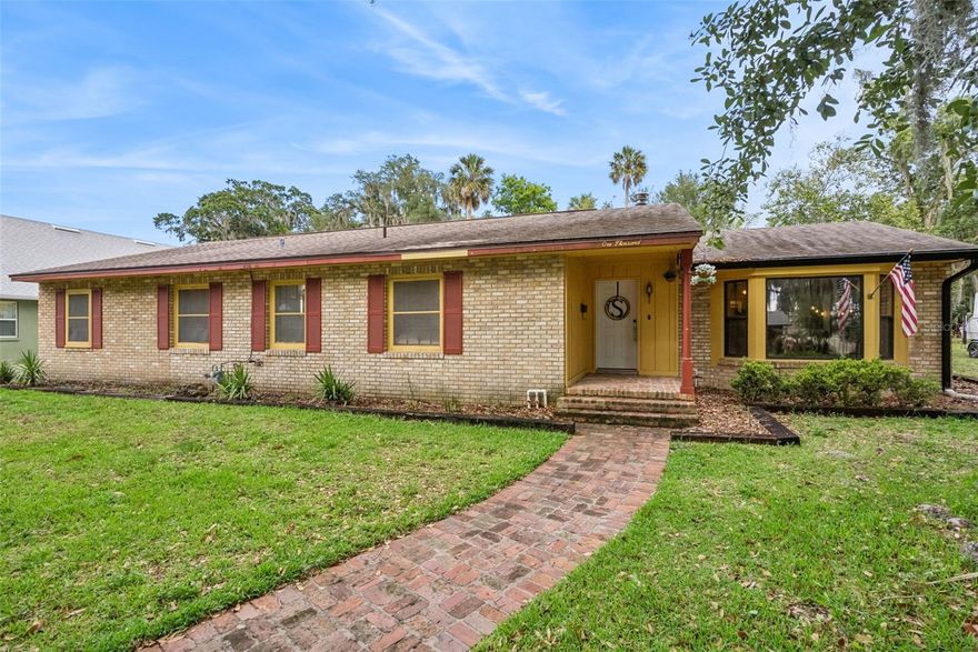 Welcome home to this spacious and versatile 5-bedroom, 3-bath home with over 3,000 sq. ft. and NO HOA in the heart of Leesburg! Featuring a private interior in-law suite complete with its own kitchenette, this flexible layout is ideal for multi-generational living or extended guests. Tucked away for a sense of privacy, you're still just minutes from shopping, dining, downtown Leesburg, Venetian Gardens, the community boat ramp to the Harris Chain of Lakes, ski beach, and endless local events and entertainment. The heart of the home showcases a beautifully updated main kitchen featuring high-level granite countertops, stainless steel appliances, rustic knotty pine cabinets, and updated tile flooring. Multiple spacious living areas provide room for everyone, while both a brick fireplace and a cast iron fireplace create the perfect setting for cozy evenings at home. Step outside and enjoy Florida living at its finest on the screened-in paver patio, perfect for year-round relaxing or entertaining. The fully fenced backyard includes a raised garden, a convenient outdoor sink, and separate golf cart parking. Whether enjoying peaceful mornings outdoors, hosting family gatherings, or enjoying boating, fishing, skiing, and more, this property offers a lifestyle as inviting as the home itself, just minutes from your front door. This is more than just a home—it’s the complete Florida lifestyle package! *Aerial photo property lines are an estimate and to be verified by buyer.