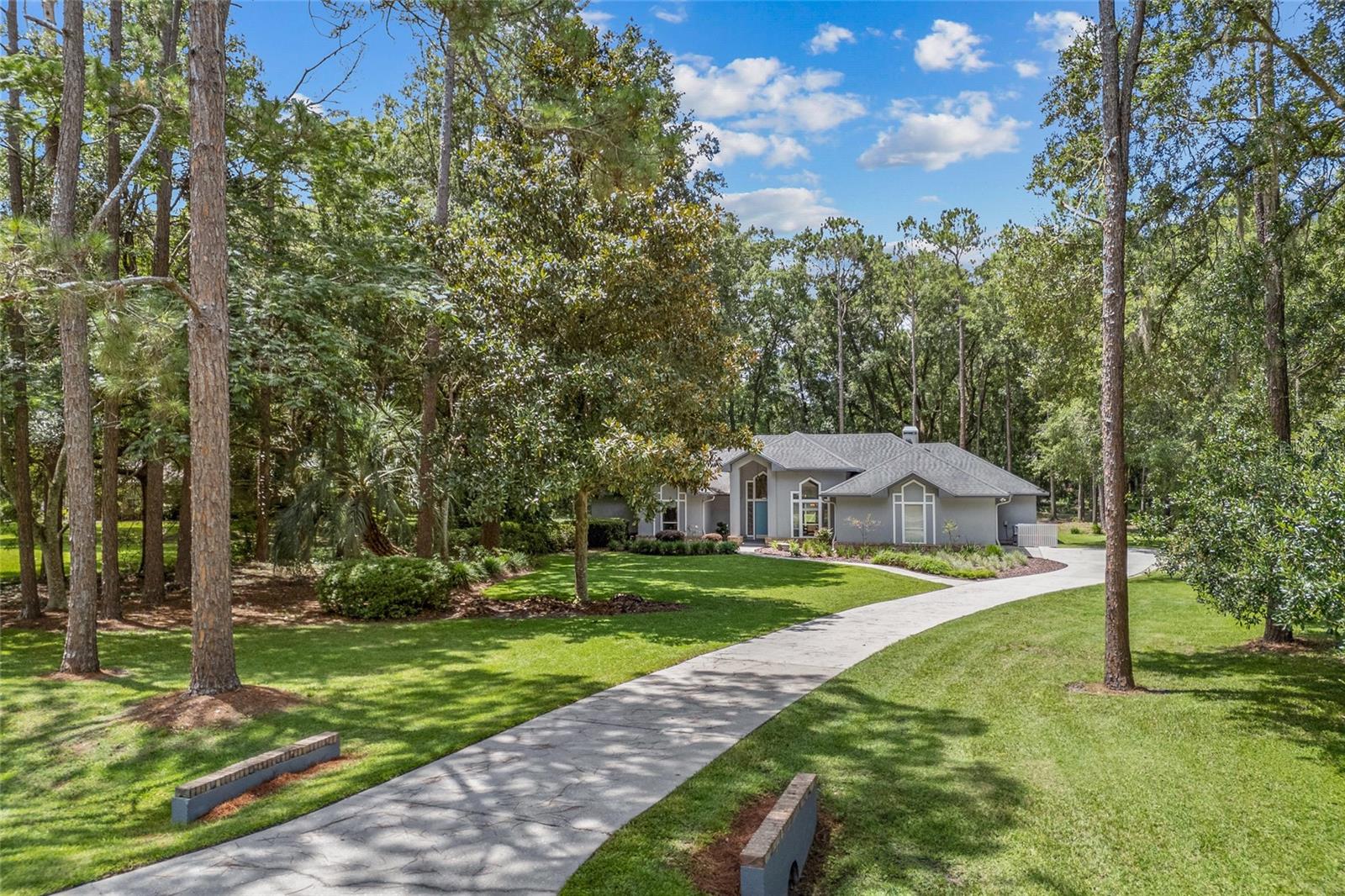 Stunning Pool Home on Over an Acre in Sought-After Jockey Club! Welcome to this beautifully maintained contemporary pool home nestled on over one acre of lush, native Florida landscaping in the highly desirable Jockey Club community. This serene, wooded lot offers privacy and a peaceful backdrop, all while being just minutes from the shops, restaurants, and parks of Tioga Town Center. Inside, you’ll love the open floor plan featuring engineered hardwood floors, travertine tile, and soaring ceilings that fill the home with natural light. The spacious kitchen overlooks the screened pool area, making it ideal for entertaining. A formal dining room and formal living room provide additional space for gatherings. The great room is a true centerpiece, complete with a wood-burning fireplace and custom built-ins, offering both comfort and style. The flexible 4-bedroom layout includes a fourth bedroom currently used as a study—with convenient access to the primary suite—making it a perfect option for a nursery, playroom, or home office. This room also has direct access to a full pool bath. Enjoy Florida living year-round in the expansive screened-in pool and patio area, featuring a large covered lanai perfect for relaxing or dining outdoors, all while overlooking your private backyard oasis. Additional highlights include: Side-entry garage with separate golf cart bay, Split floor plan offering privacy for the 2nd and 3rd bedrooms with a shared full bath and pocket door separation, and a well-appointed laundry room just off the kitchen for added convenience. This home is the perfect blend of comfort, function, and location—a rare find in today’s market!