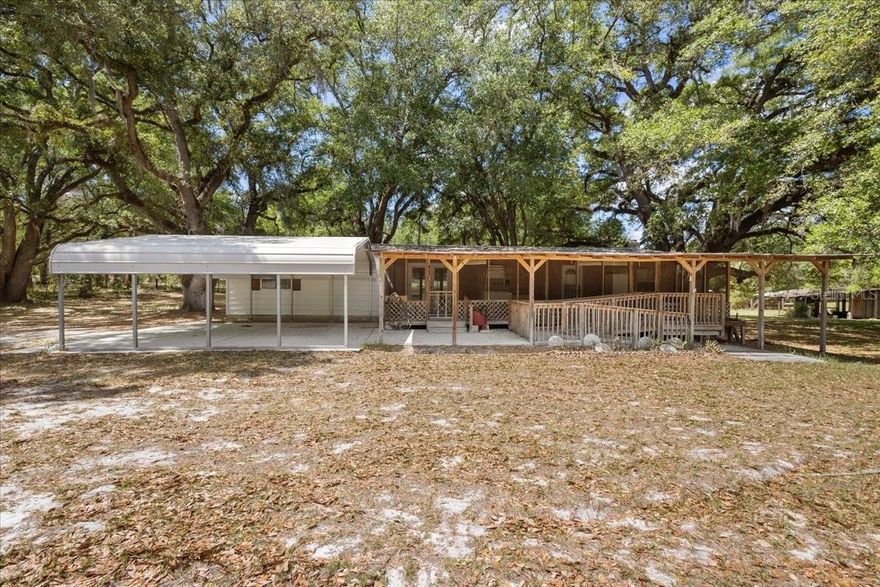 LARGE GRANDDADDY OAKS and shady back yard.....Tucked away in the peaceful countryside of Bell, this charming 2-bedroom, 2-bath home sits on 7 BEAUTIFUL ACRES with paved road frontage, offering the perfect blend of privacy and accessibility. The property features a mix of open, cleared pasture and a scenic wooded area filled with native hardwoods—ideal for enjoying nature, recreation, or creating your own mini farm. The home was thoughtfully updated in 2016, providing modern comfort while maintaining its inviting character. A large great room with gas fireplace will be the room your family will love. A whole-house generator offers added peace of mind, ensuring you’re always prepared no matter the season. Stretching the full length of the home, a spacious screened porch provides the perfect spot to relax, entertain, and take in the tranquil surroundings year-round. Additional improvements include a metal garage/workshop, perfect for hobbies, storage, or equipment, as well as a convenient 2-car carport. With plenty of room to roam, garden, or bring animals, this property offers endless possibilities for country living while still being just a short drive to nearby amenities. Don’t miss your chance to own a slice of North Florida paradise!
