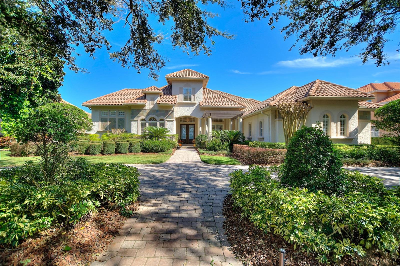 Nestled along the pristine shores of Big Sand Lake in the highly desirable Dr. Phillips community, this 5,562 sq ft, stunning 5-bedroom, 5.5-bathroom luxury home offers an unparalleled combination of elegance, comfort, and scenic beauty. Designed for both luxurious living and entertaining, every corner of this expansive residence exudes sophistication, from the high-end finishes to the thoughtfully crafted spaces that make the most of the idyllic lakefront views. Stepping into this home, you’re immediately welcomed by an impressive grand foyer that sets the tone for the elegance and luxury that awaits. The space is defined by its soaring coffered ceilings, a design element that adds both depth and architectural detail to the room.
As you walk through the foyer, your gaze is naturally drawn forward to the breathtaking view beyond. Through the formal living room, large floor-to-ceiling windows frame a panoramic vista of the shimmering lake.
The renovated kitchen with granite counter tops has an open-concept layout, which connects the kitchen to the adjoining living and dining areas.
Tucked away just off the kitchen, the butler’s pantry serves as an essential extension of the culinary space. It’s more than just a storage area—it’s a well-equipped staging space for hosting and entertaining.
Upon entering the Owner suite, you're immediately captivated by the room's sheer size and its seamless blend of sophistication and comfort. Floor-to-ceiling windows allow natural light to flood the room while offering panoramic views of the shimmering lake. The attached ensuite bathroom is a masterpiece in its own right, designed with the finest materials and every luxury imaginable. Now imagine a two-floor master closet that feels more like a private boutique, where luxury meets functionality, and every detail is designed to make getting dressed an indulgent experience. This dream closet is the ultimate statement in both style and organization, offering not only ample storage but also a sense of elegance and personal retreat.
The main floor features three additional bedrooms, each thoughtfully designed to provide comfort, style, and functionality. The fifth bedroom, located on the upper level, is an ideal teen retreat or nanny suite. This spacious and versatile room with full bath provides a serene escape while still being connected to the heart of the home.
Installed in 2016 was a new composite wood 115 ft dock and covered boat slip. This dock ensures your vessel is protected from the elements, keeping it sheltered from harsh sun and rain while being easily accessible for spontaneous lake outings. In addition to the dock, a 100-foot retaining wall or berm was built along the waterfront, serving both a practical and aesthetic function. The retaining wall helps prevent shoreline erosion, protecting the integrity of the property.
This residence on Big Sand Lake is more than just a home—it’s a lifestyle, where every day feels like a vacation. With unmatched views, high-end finishes, and a location in one of Orlando’s most sought-after communities, this luxury property is a rare opportunity to own a piece of paradise. Located in the desirable Dr. Phillips area, this home is minutes away from Orlando’s finest dining, shopping, and entertainment, including Restaurant Row and Walt Disney World. As an added bonus this home is equipped with a whole home generator.