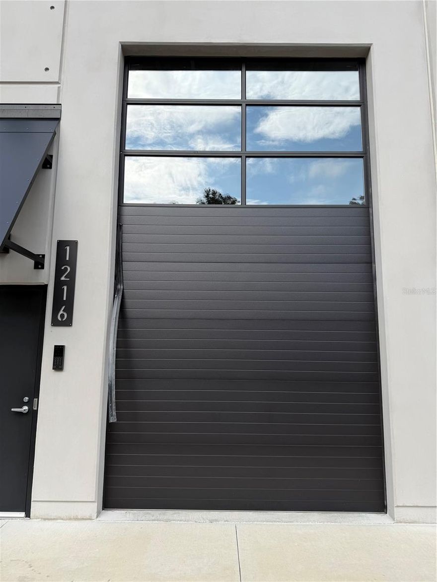 Located within The Motor Enclave, this 738-square-foot private garage condominium offers a secure, climate-controlled environment ideal for automotive storage, recreational use, or customization. The space provides excellent flexibility for collectors or enthusiasts seeking a ownership experience within a gated, professionally managed community. Thoughtfully configured for both storage and lifestyle use, the unit provides ample room for prized vehicles, recreational equipment, or a personalized lounge setup. This unit is a blank canvas that allows for free-standing structures, giving you the freedom to design your space without anchoring to the walls. Gated community with 24/7 security, ensuring the safety of your valuable assets. Easy access to major highways I-75 and I-4. With a Membership to the Motorsports club, garage owners have access to community amenities including a 1.72-mile track designed by Hermann Tilke, a 100-acre off road experience, a 2-acre skid pad, and a resort style pool. Located within the community is a 37,000 sq. ft. event center perfect for gatherings, networking, and attending public and private events. Ideal as a private retreat, investment, or extension of your automotive passion, this unit delivers unmatched convenience in Tampa.